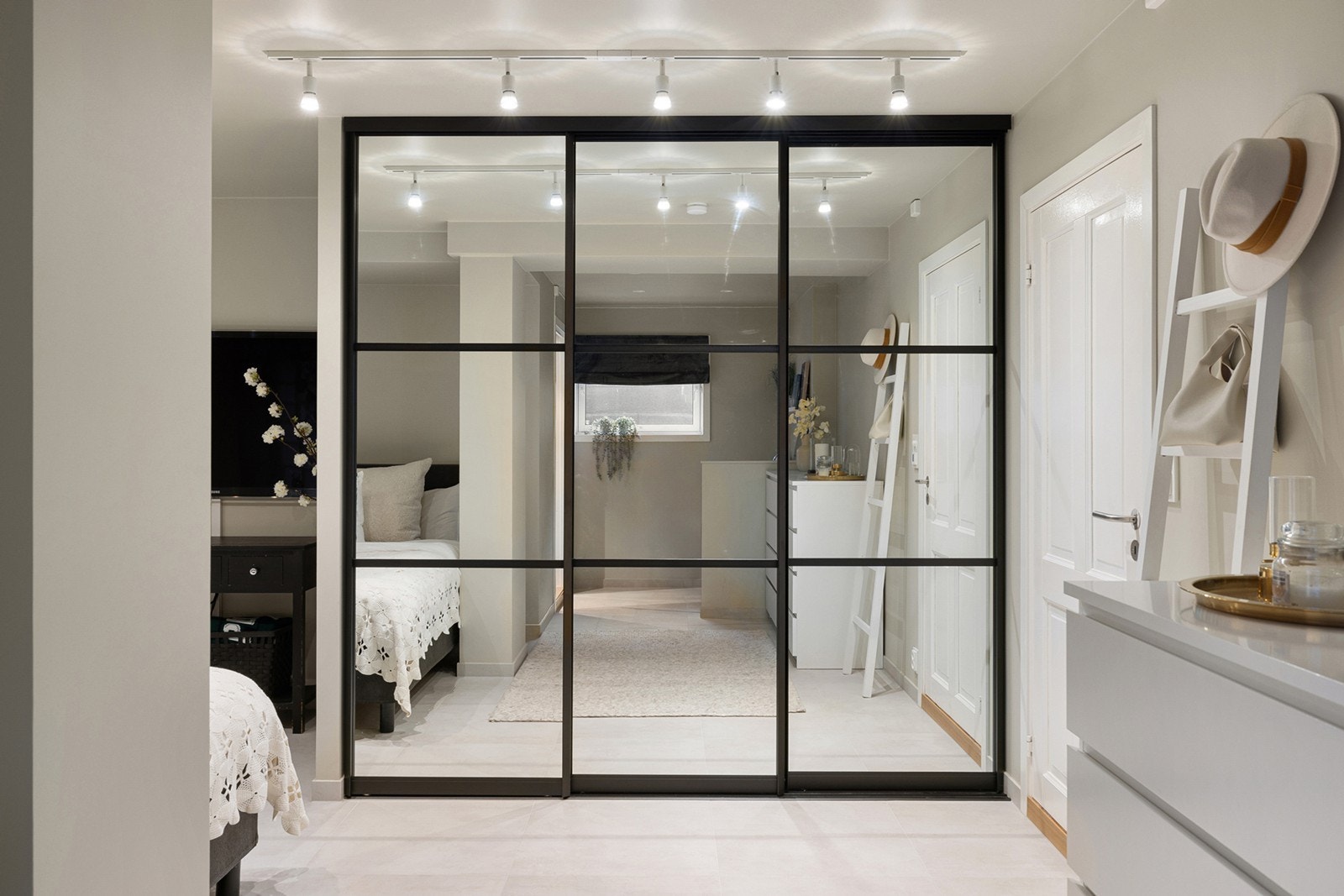 Praktisk skyvedørsgarderobe med sorte profiler og speilflater gir rikelig med oppbevaringsplass, samtidig som det bidrar til en romfølelse og et stilrent preg. Galleribilde