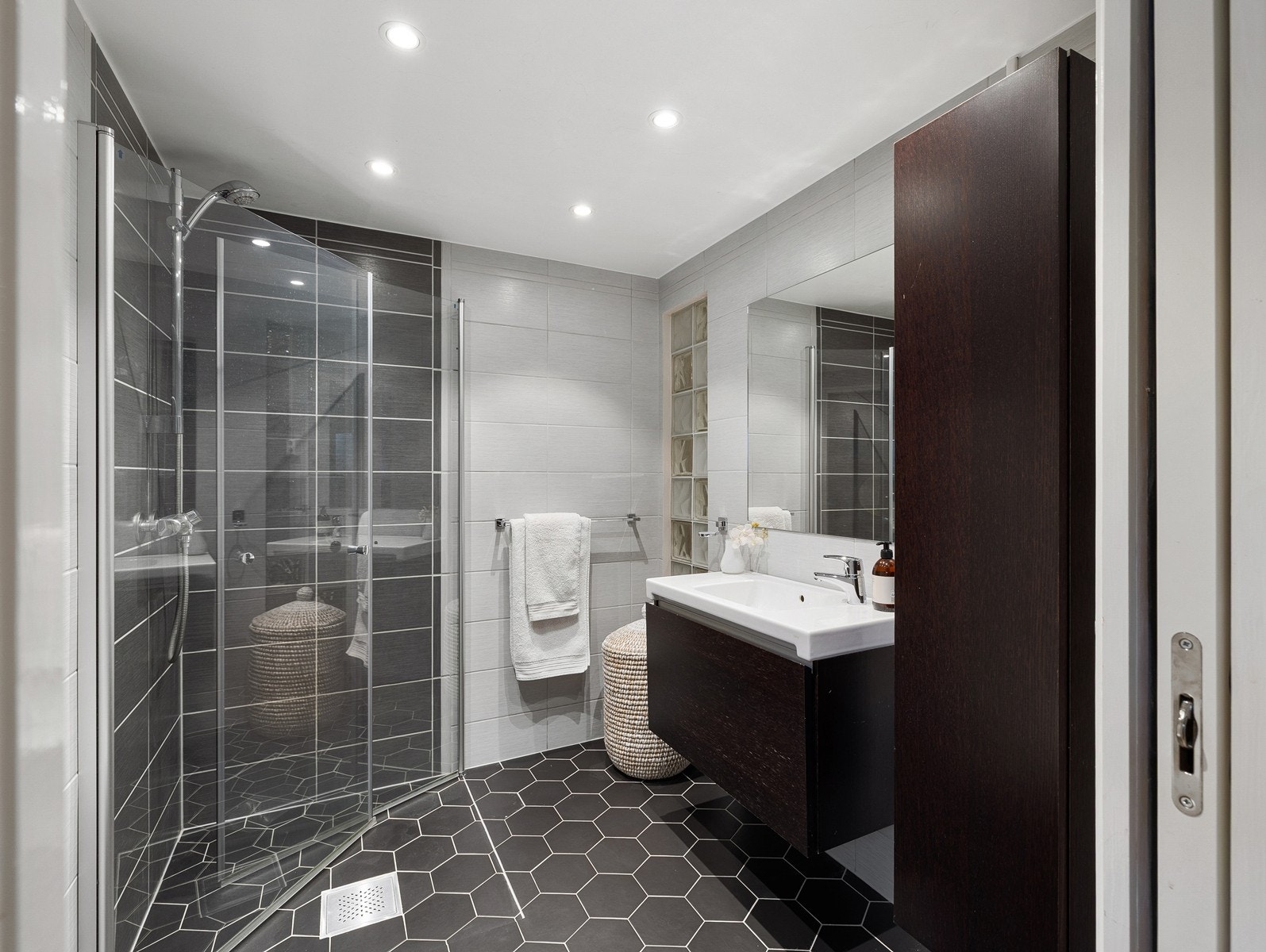 Flislagt bad med moderne uttrykk. Badet har fliser på både gulv og vegger, og det er opplyst at flis er lagt på eksisterende fliser i 2019. Badet er utstyrt med gulvvarme for økt komfort. Galleribilde