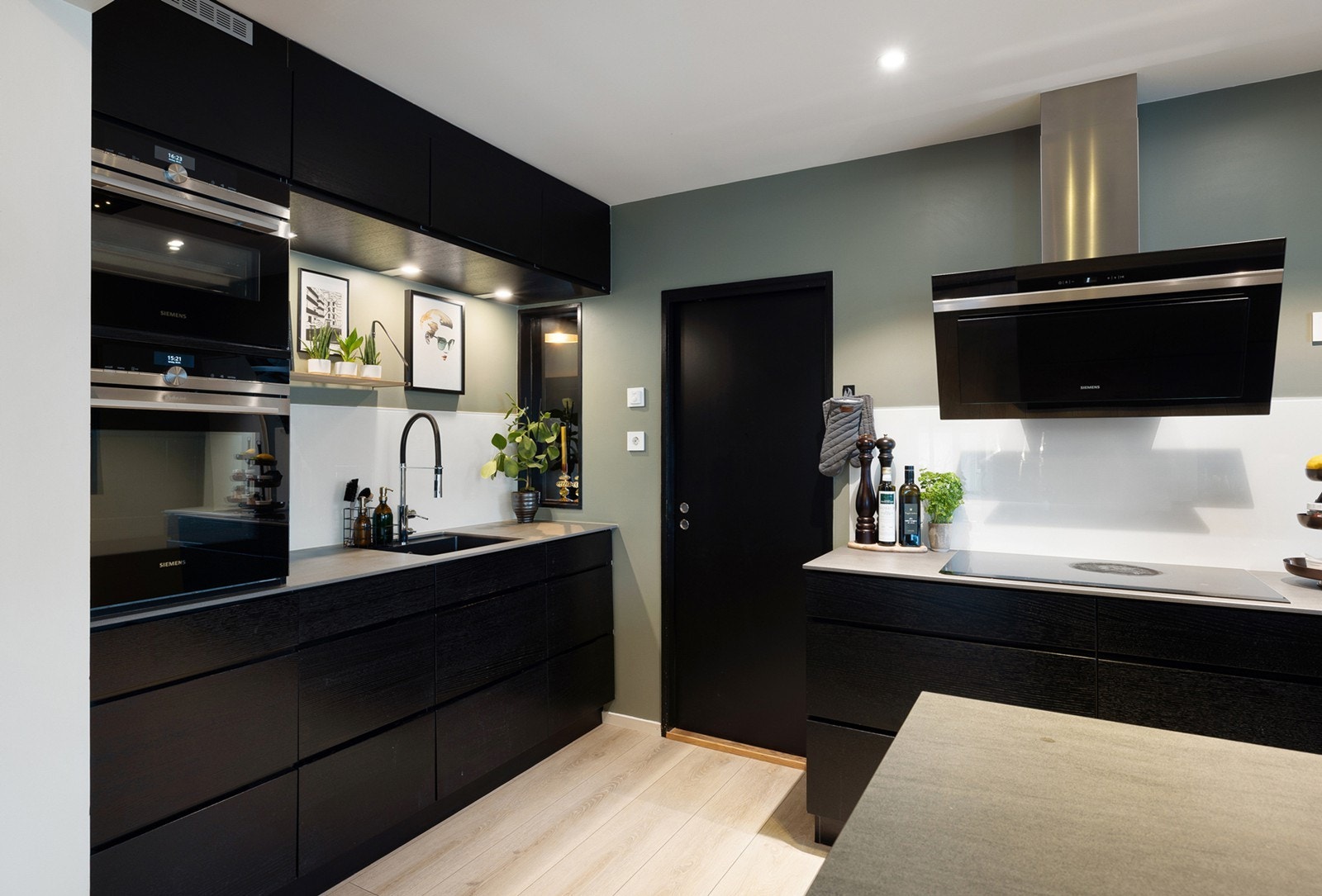 Stilrent og moderne kjøkken i åpen løsning mot spisestue, som gir en sosial og funksjonell romfølelse. Galleribilde