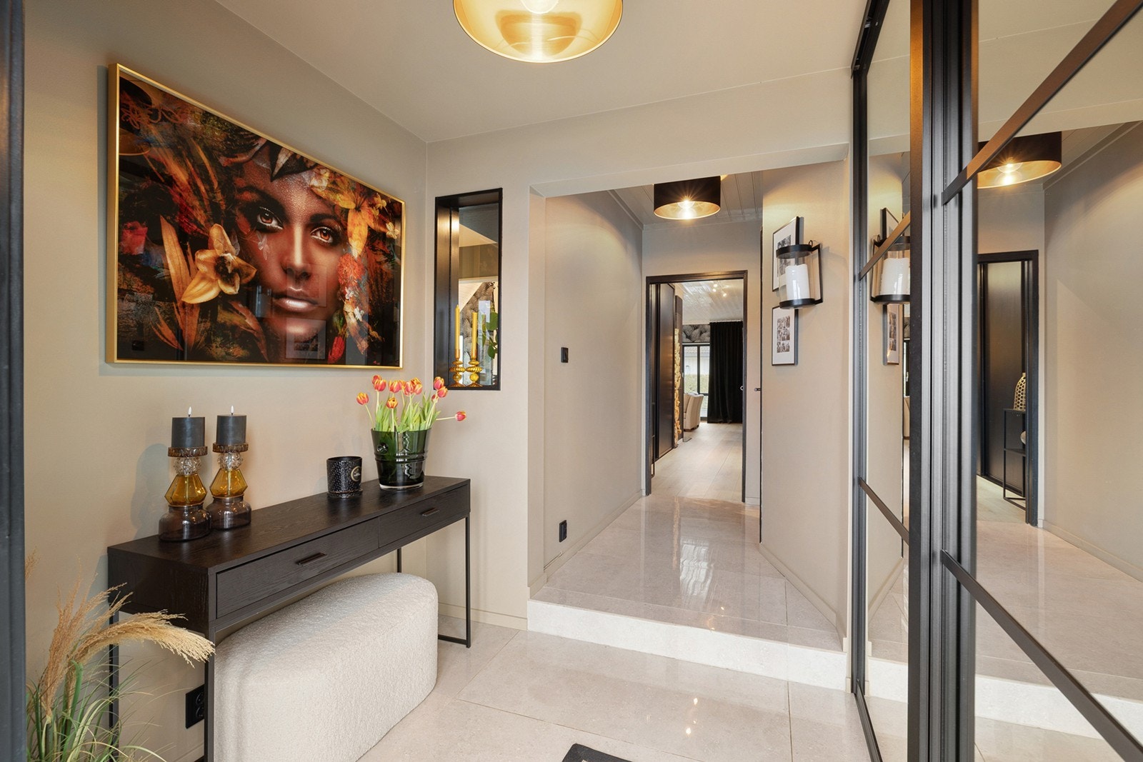 Innbydende og stilren entré med flislagt gulv og gode oppbevaringsmuligheter i skyvedørsgarderobe med speilfronter. Galleribilde