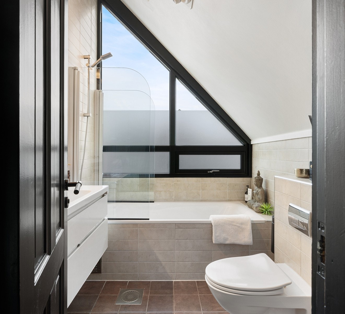 Skråtak og vindu gir rommet særpreg samt godt med naturlig lys og ventilasjon. Videre er det et innbygd badekar med dusjløsning. Galleribilde