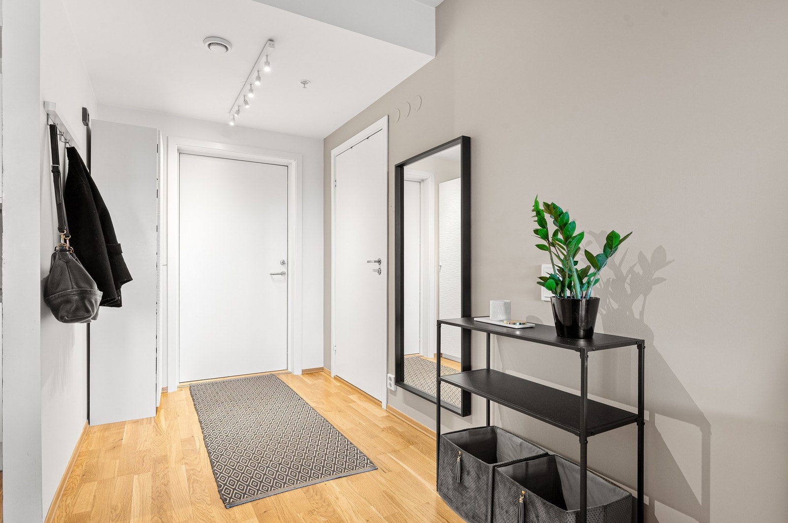 Entré med smarte løsninger for oppbevaring av yttertøy og sko, kombinert med speil og møblering som gir en funksjonell hverdag. Galleribilde