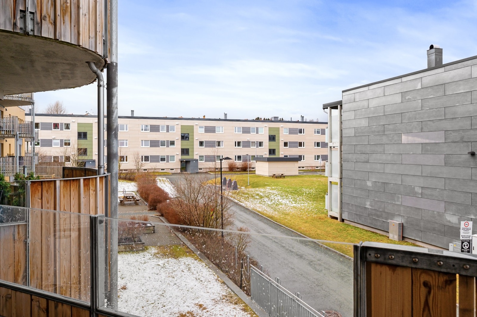 Balkongen har en fin plassering med utsikt over felles uteområder og bebyggelse, som gir både lys og luft rundt boligen. Galleribilde