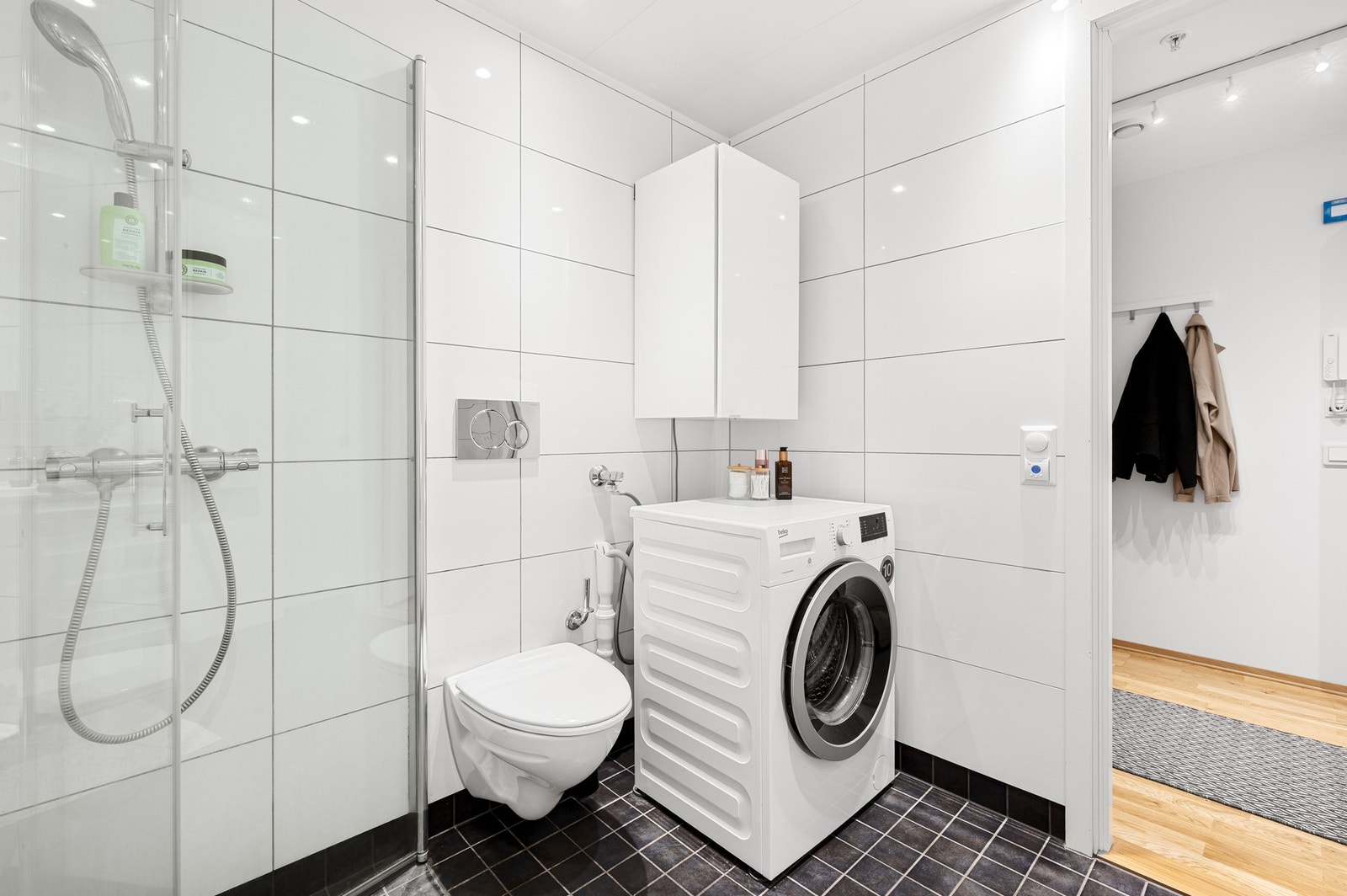 Badet er utstyrt med dusjhjørne, opplegg for vaskemaskin og vegghengt toalett. Galleribilde