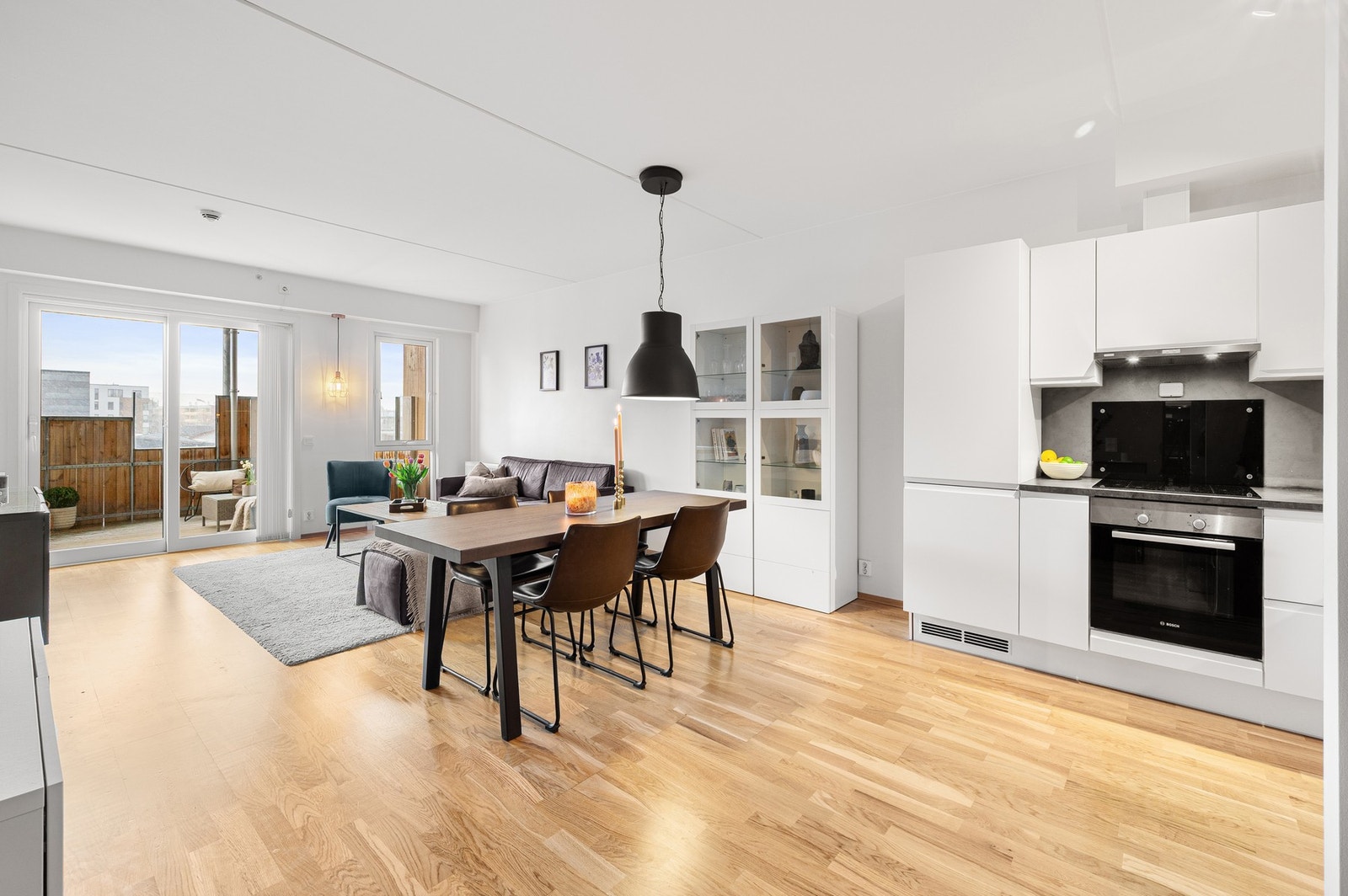 Lys og romslig stue med åpen kjøkkenløsning som skaper en sosial og innbydende atmosfære. Galleribilde