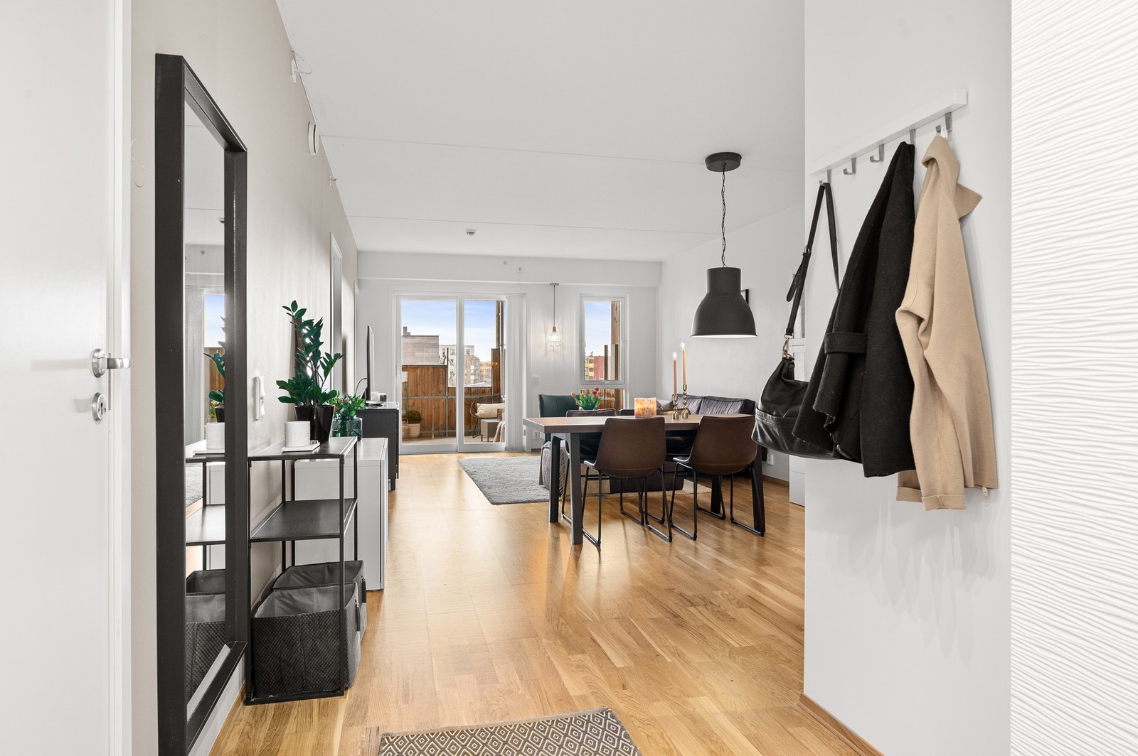 Lys og romslig gang med god takhøyde og plass til både oppbevaring og møblering. En fin overgang til boligens åpne stue- og kjøkkenløsning. Galleribilde