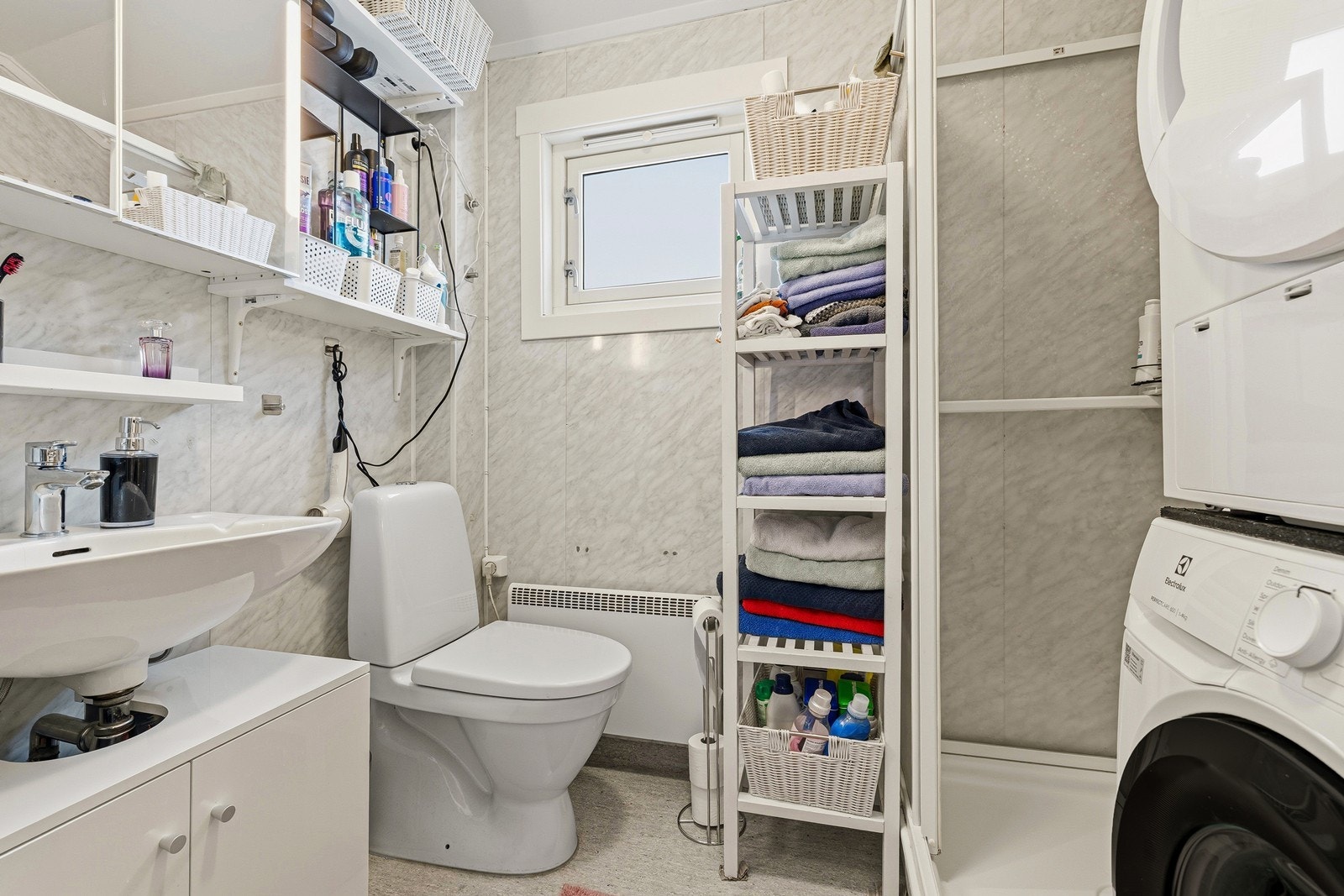 Badet har enkel innredning og veggservant, toalett og det er dusjkabinett. Opplegg til vaskemaskin. Galleribilde