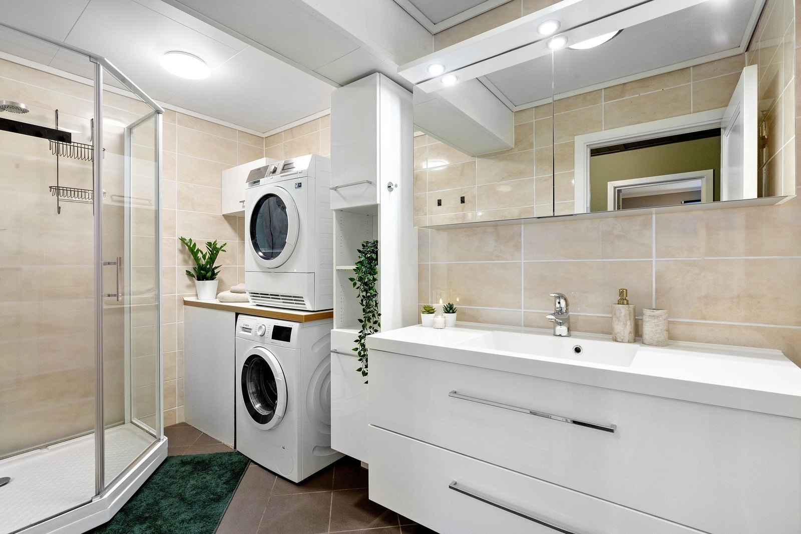 Badet er slått sammen med vaskerommet fra originale tegninger og er på 5,4 kvm med stor baderomsinnredning med praktiske skuffer, dusjkabinett og egen "vaskerom-seksjon" Galleribilde