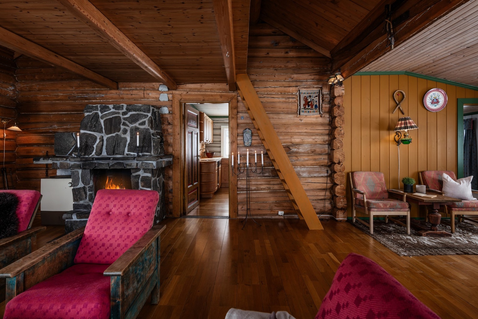 Romslig stue med naturlig lys, peis og åpen løsning mot kjøkkenet Galleribilde