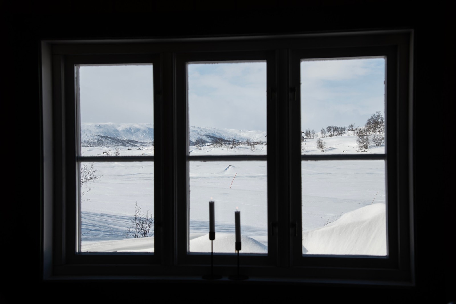 Store vinduer med utsikt mot snødekte fjell og landskap gir en luftig og lys atmosfære Galleribilde