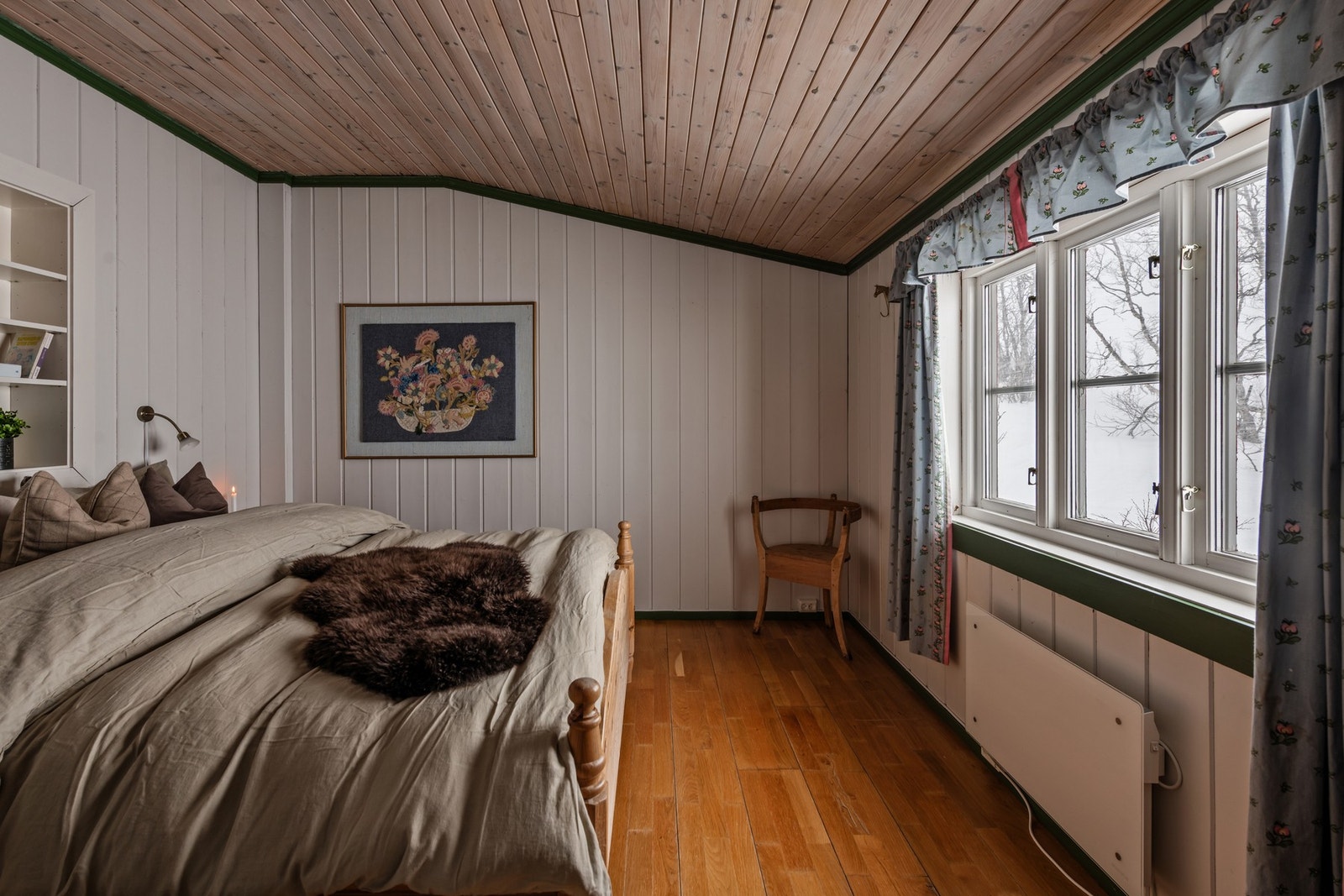 Våkne til fjellets ro i et soverom med panelvegger og skråtak Galleribilde