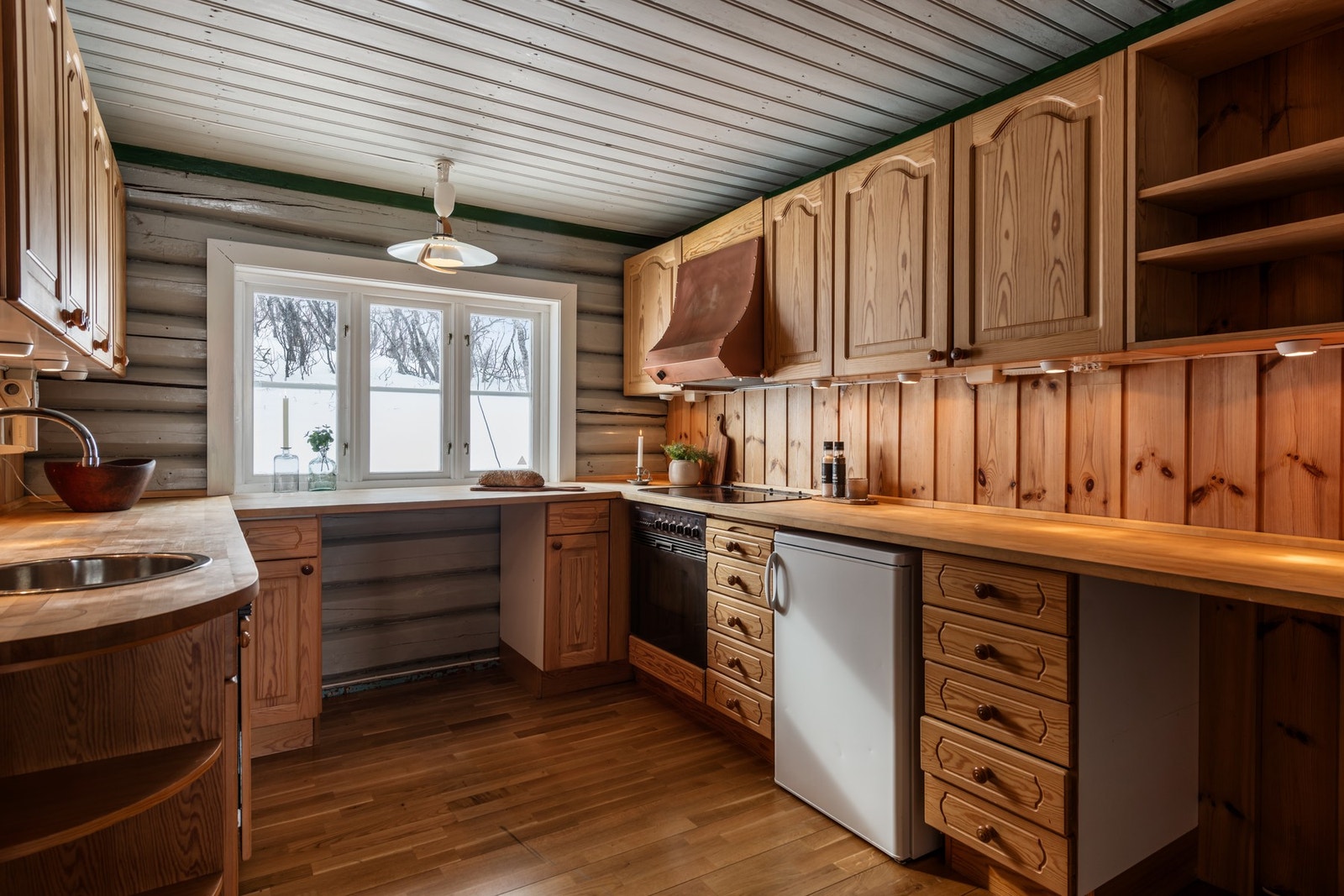 Kjøkkenet har god benkeplass, overskap og underskap i heltre, samt naturlig lys fra stort vindu. Galleribilde