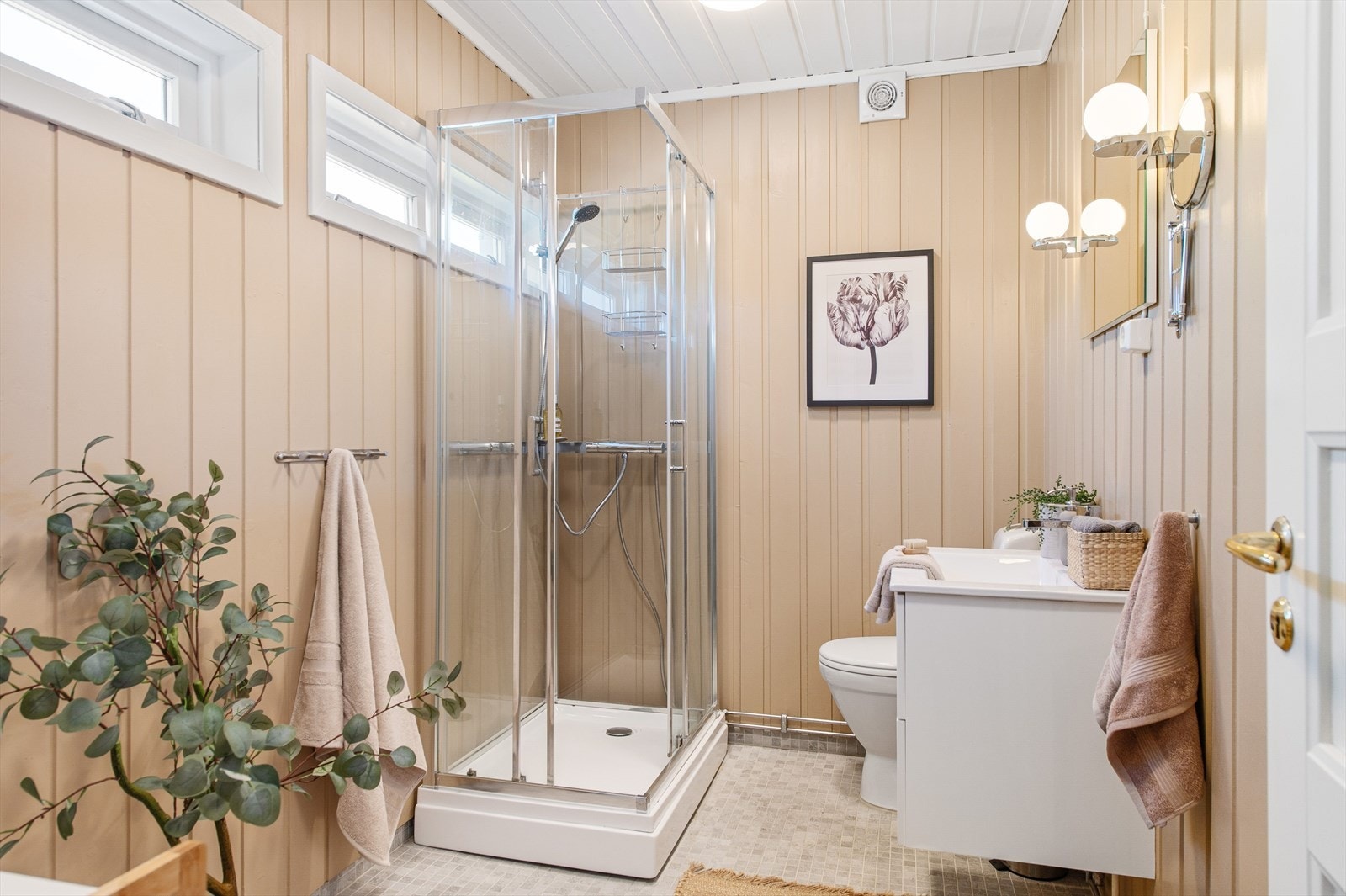 Bad med flislagt gulv og servant med underskap for lagring Galleribilde