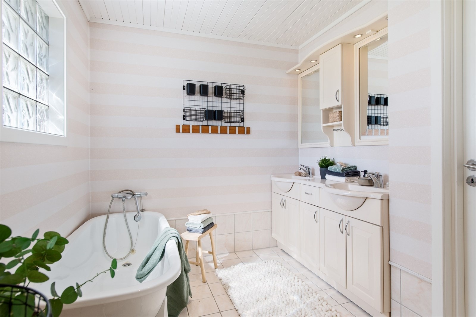 Baderom med badekar og dobbelservant med underskap for lagring Galleribilde