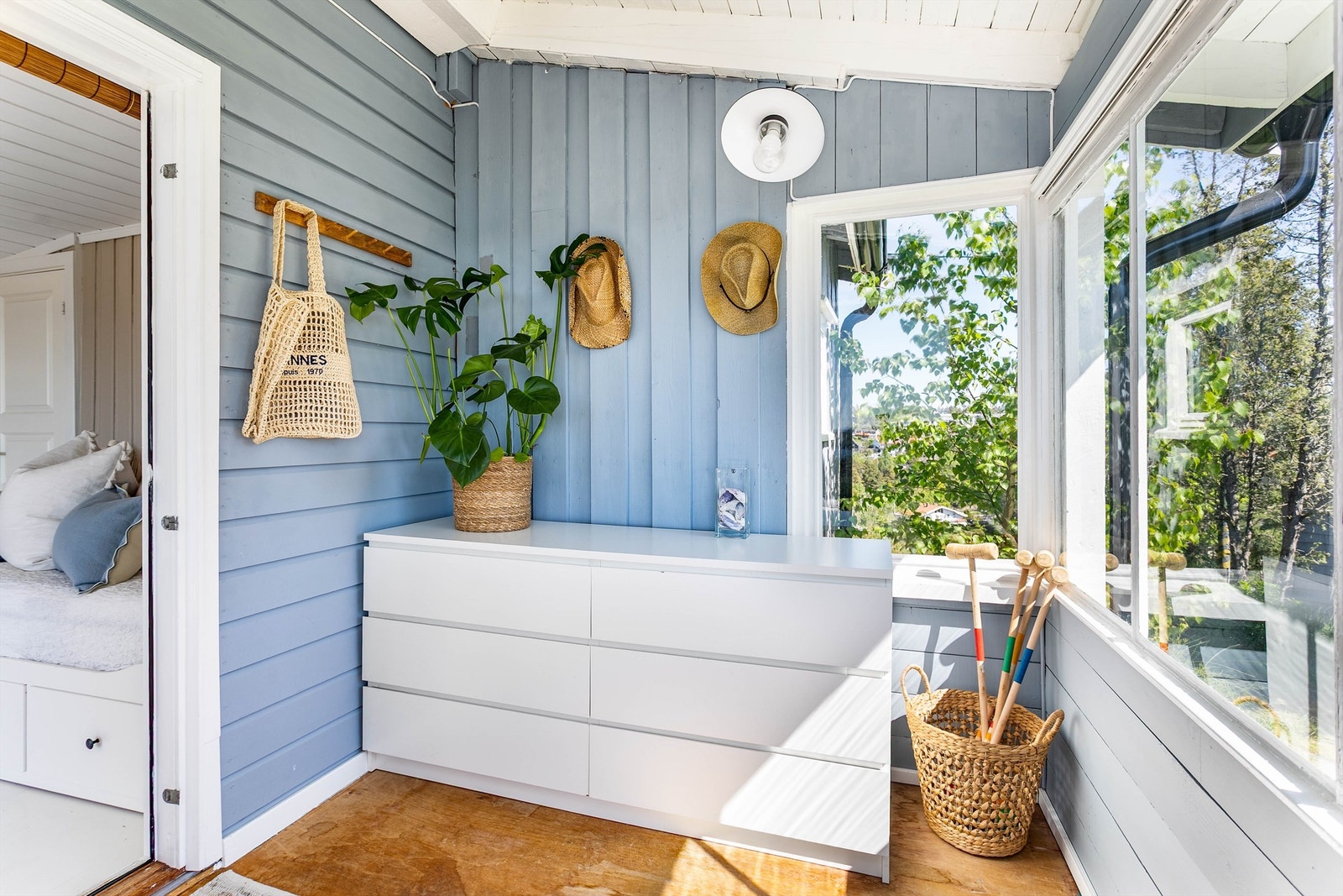 Adkomst til hyttas indre skjer gjennom et overbygget og solfylt vindfang hvor det er rom for oppbevaringsmøbler. Galleribilde