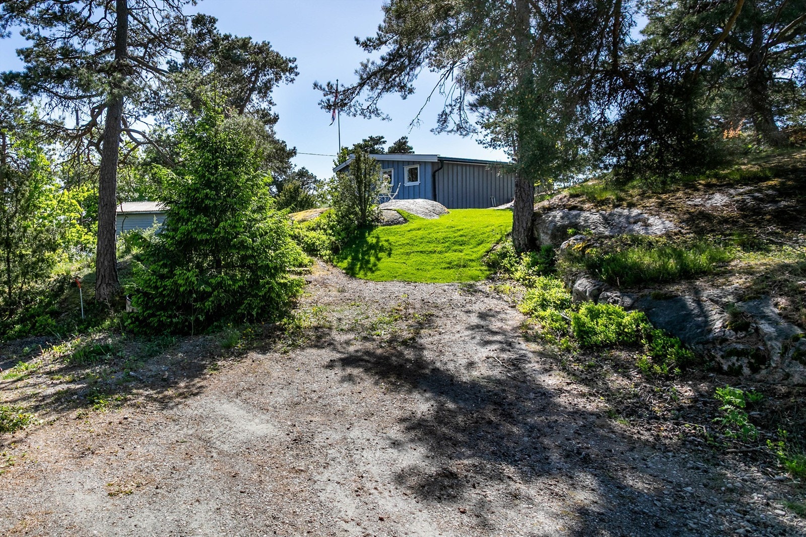 Eiendommen ligger bokstavelig talt innerst i Skutebaugveien som ender ved tomtegrensen. Her er det biloppstillingsmulighet. Galleribilde