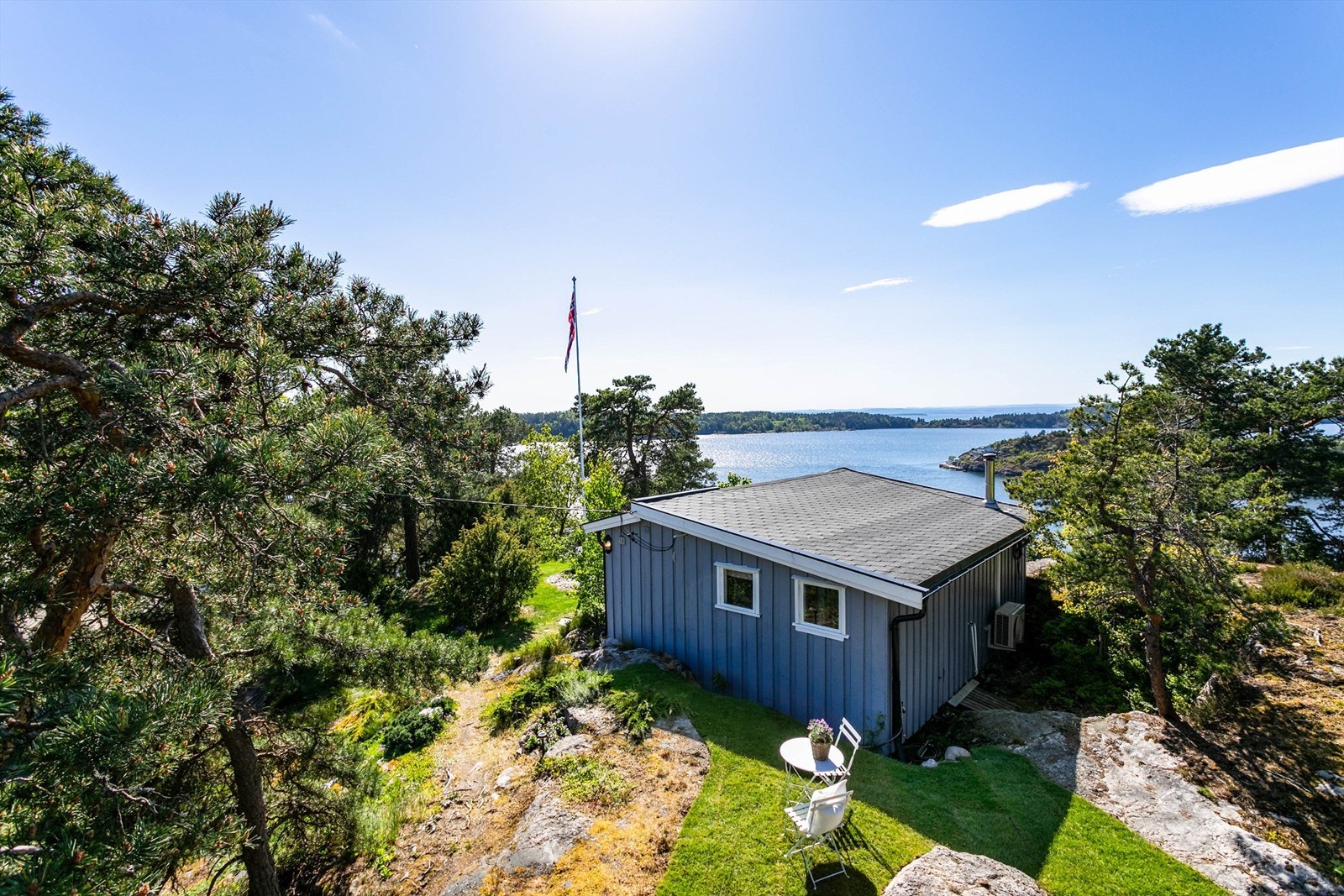 Ny hage med ferdigplen er anlagt mellom de lave fjellknausene på hyttas skjermede bakside. Galleribilde