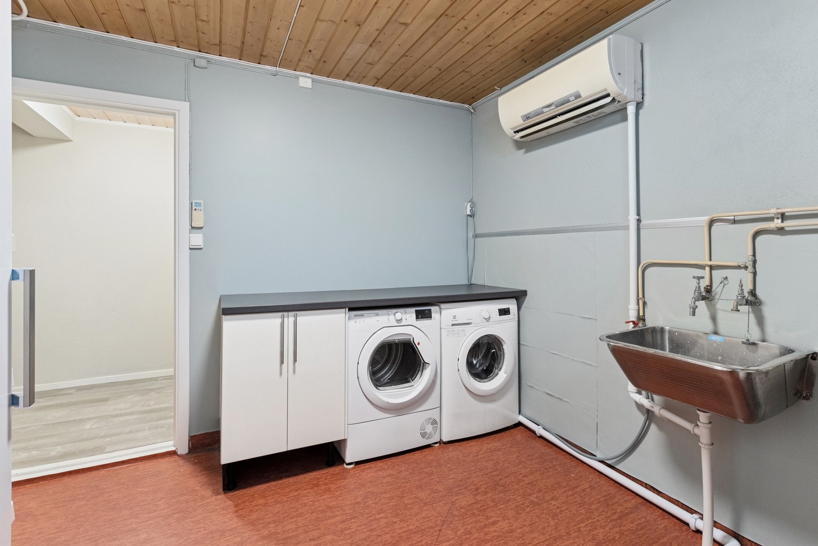Eget vaskerom i kjelleretasjen med vegghengt vaskekum og opplegg for vaskemaskin og tørketrommel. Enkel innredning med underskap og benkeplate. På vaskerommet er det montert varmepumpe. Galleribilde
