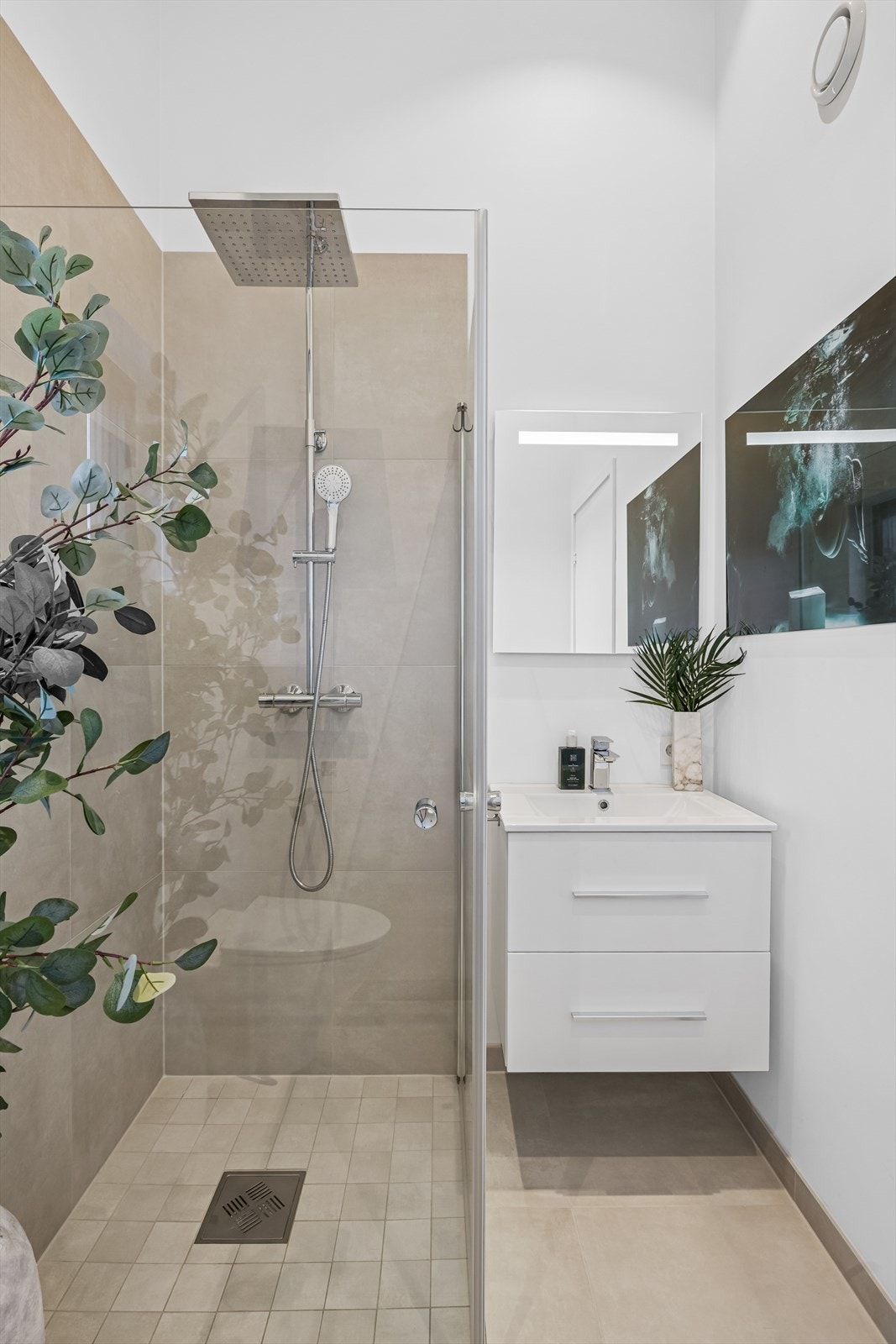 Rommet er innredet med baderomsinnredning, vegghengt toalett og dusjsone. Galleribilde