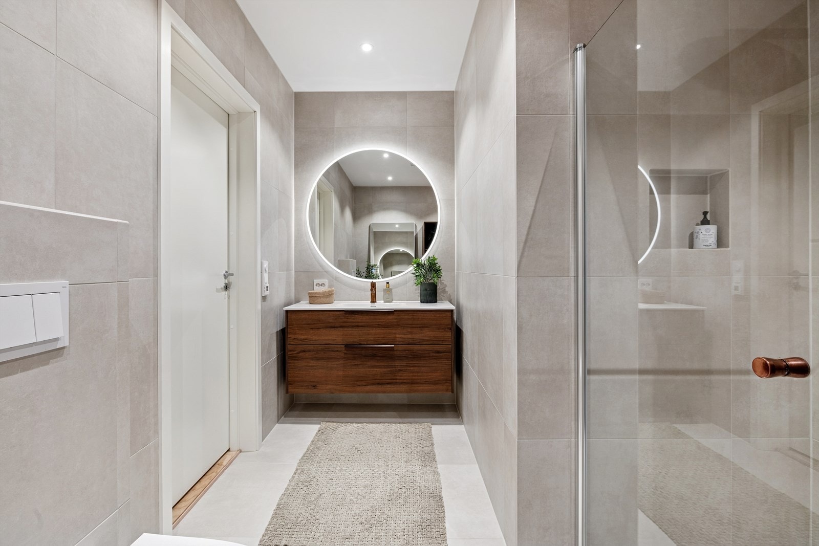 Rommet er utstyrt med baderomsinnredning, vegghengt toalett og dusjvegg med garnityr. Galleribilde