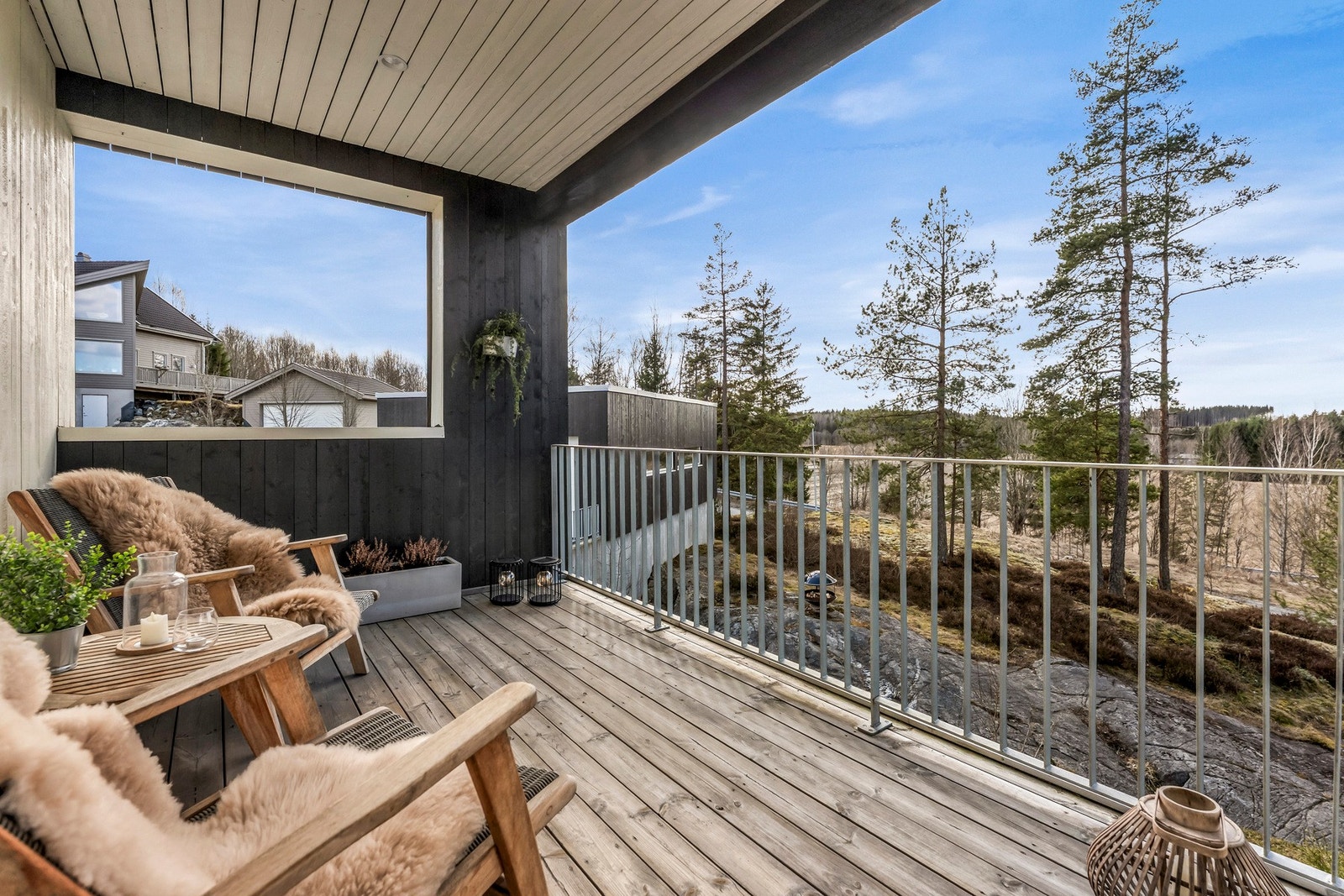 Overbygd balkong med utsikt over naturen som omkranser huset Galleribilde