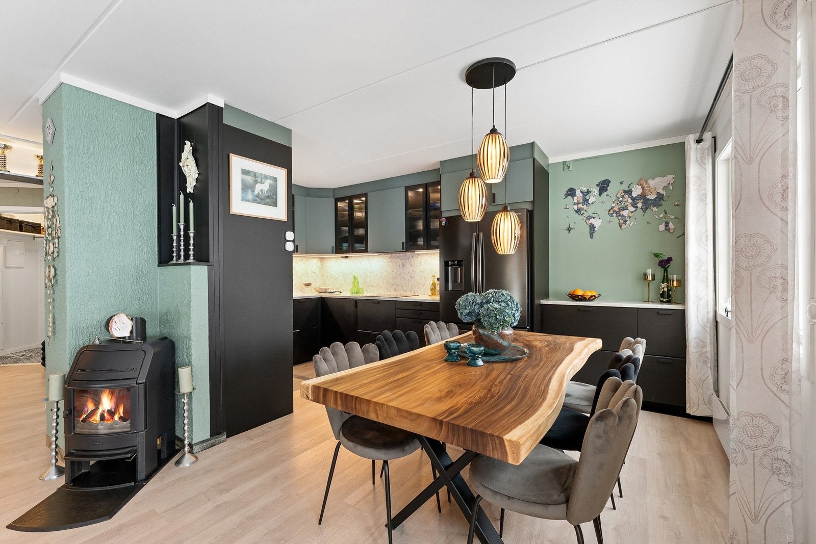 I åpen løsning mot stuen finner du et lekkert kjøkken fra 2022 med glatte fronter på skap og skuffer, og benkeplate av stein med nedfelt kjøkkenvask Galleribilde