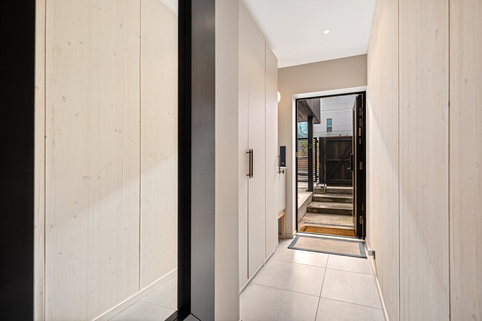 I entréen møtes du av store, praktiske garderobeskap og flislagt gulv. Lekre beisede finer-plater i gangen skaper et eksklusivt inntrykk. Galleribilde