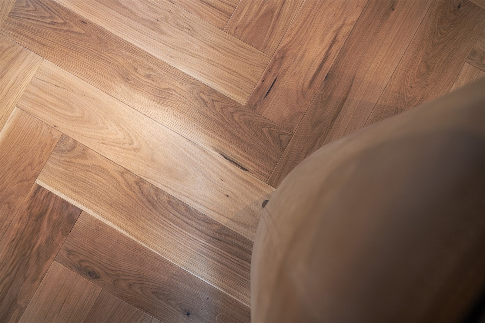 Nærbilde av den eksklusive, gjennomgående fiskebensparketten i eik - et tidløst kvalitetsvalg som gir boligen et sofistikert og harmonisk uttrykk. Den varme eiketonens spill og den klassiske leggemetoden løfter helhetsinntrykket! Galleribilde