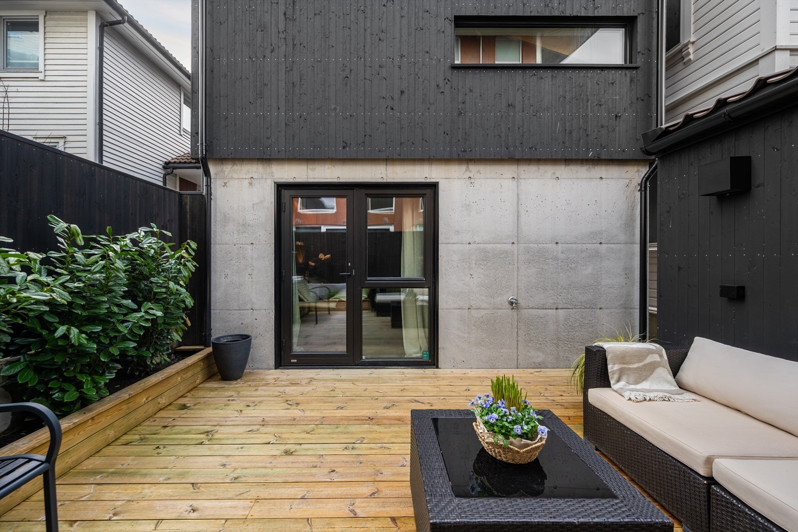 Legg merke til den moderne fasaden med en kombinasjon av betong og mørkt trepanel. Galleribilde