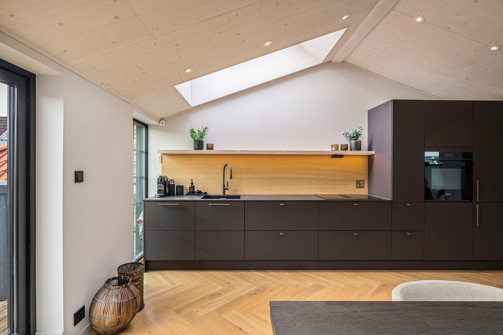 Kjøkkenet fra kvalitetsleverandøren Svanekjøkken. Det har en mørk, elegant innredning med slette fronter og integrerte hvitevarer. Kjøkkenventilator med kullfilter. Galleribilde