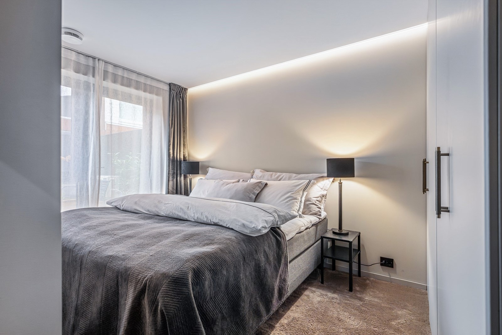 Soverommet har en rolig atmosfære med indirekte belysning og heldekkende teppe. God garderobeløsning. Galleribilde