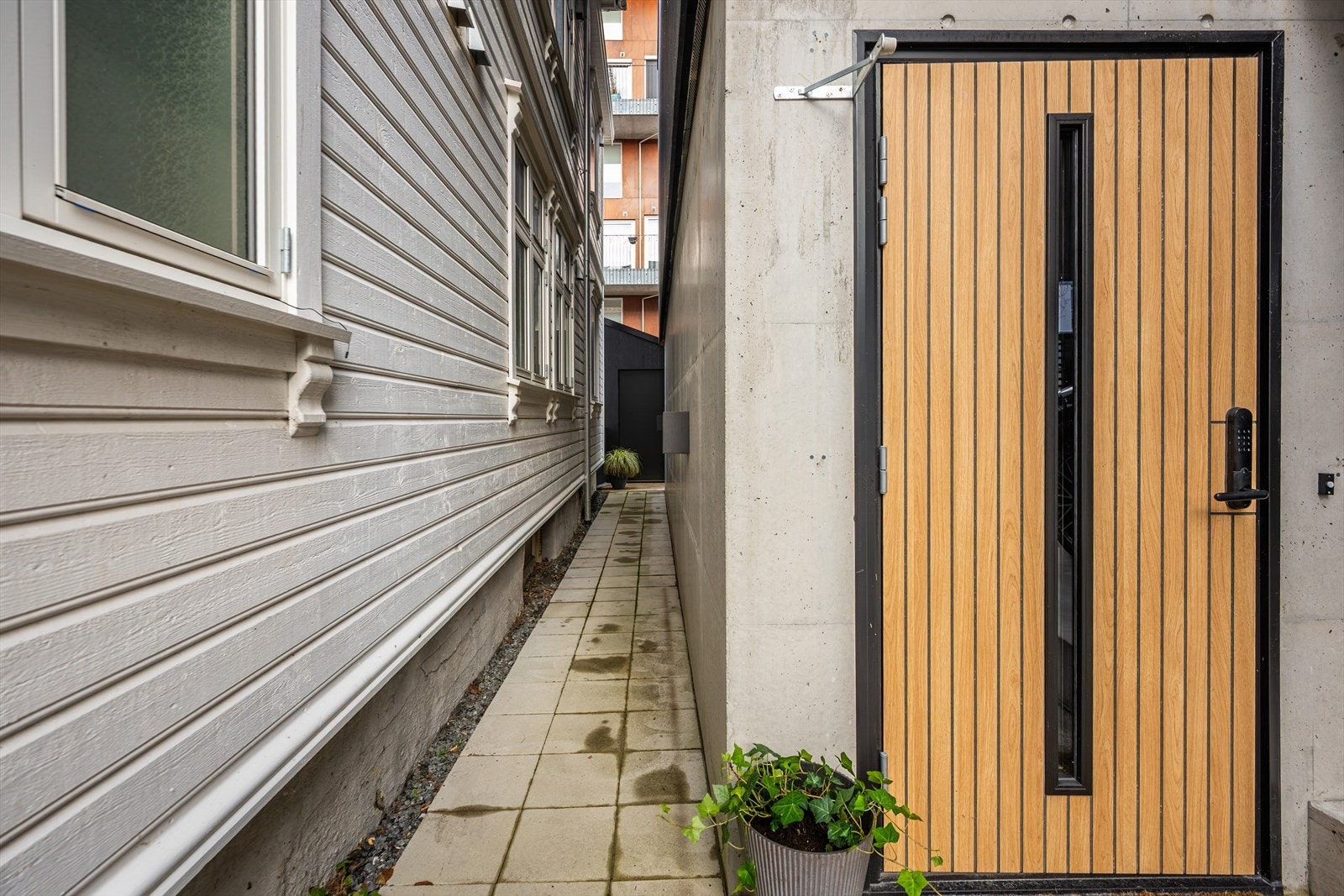 Inngangspartiet er lettstelt - solid og moderne, med dør i eik og elektronisk kodelås. Galleribilde