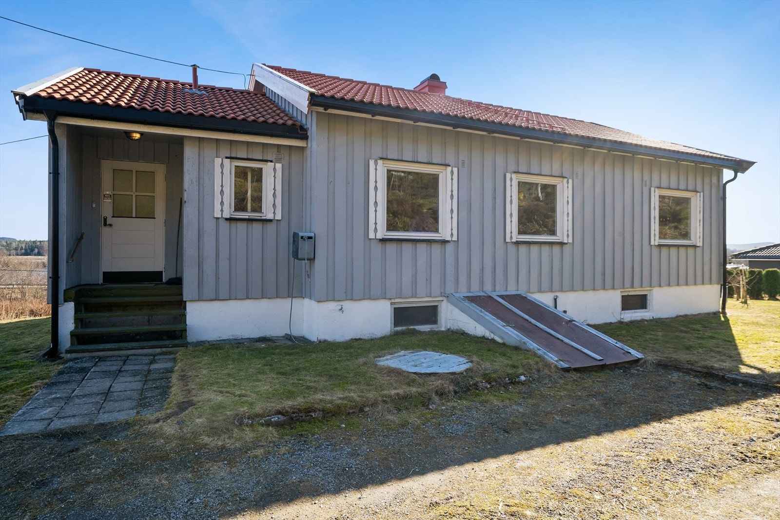 Enebolig fra 1966 med takoverbygget inngangsparti. Taket ble tekket med ny betongtakstein i 2023. Galleribilde