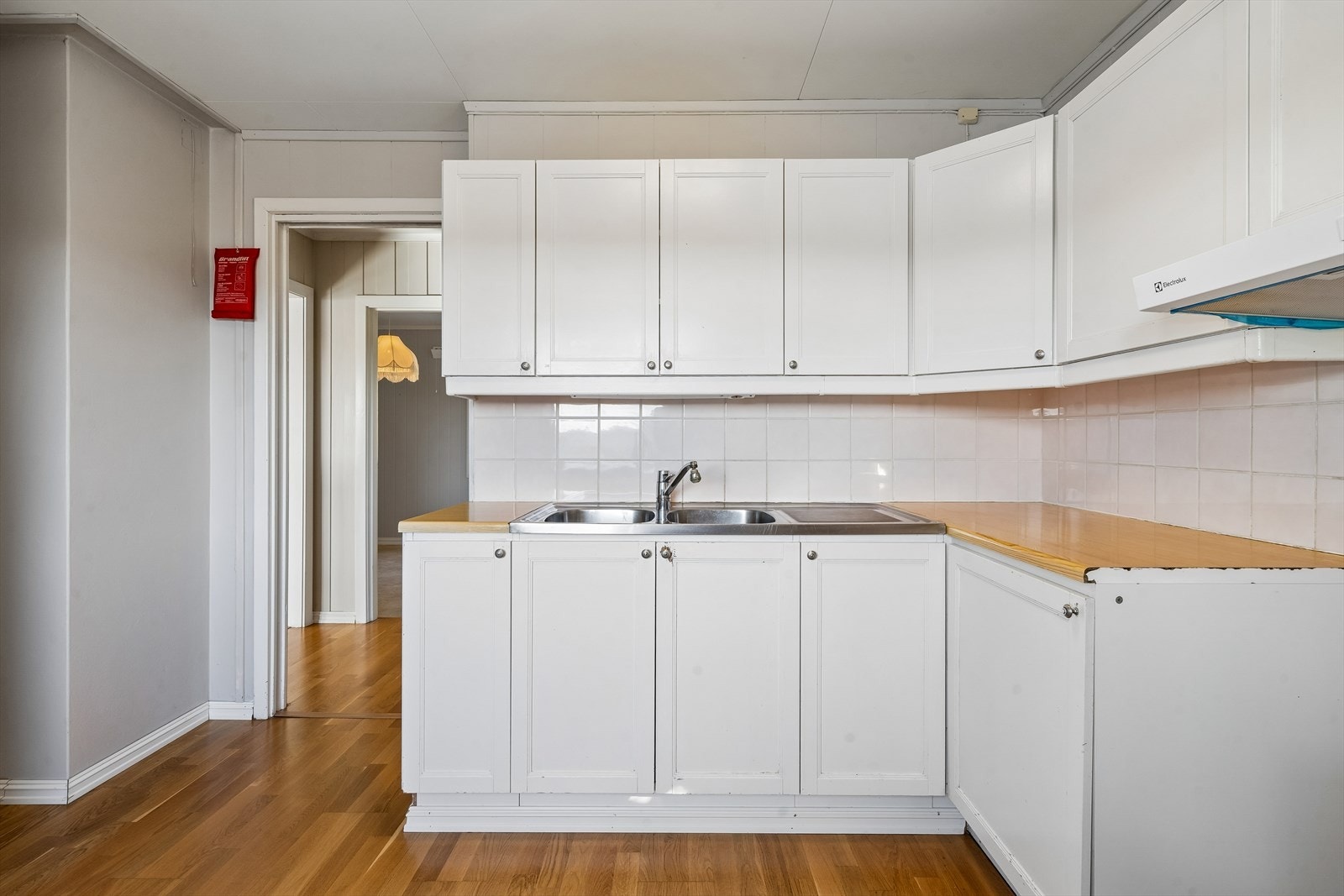 Kjøkkeninnredning fra 1990 med malte fyllingsdører og laminat benkeplate. Galleribilde