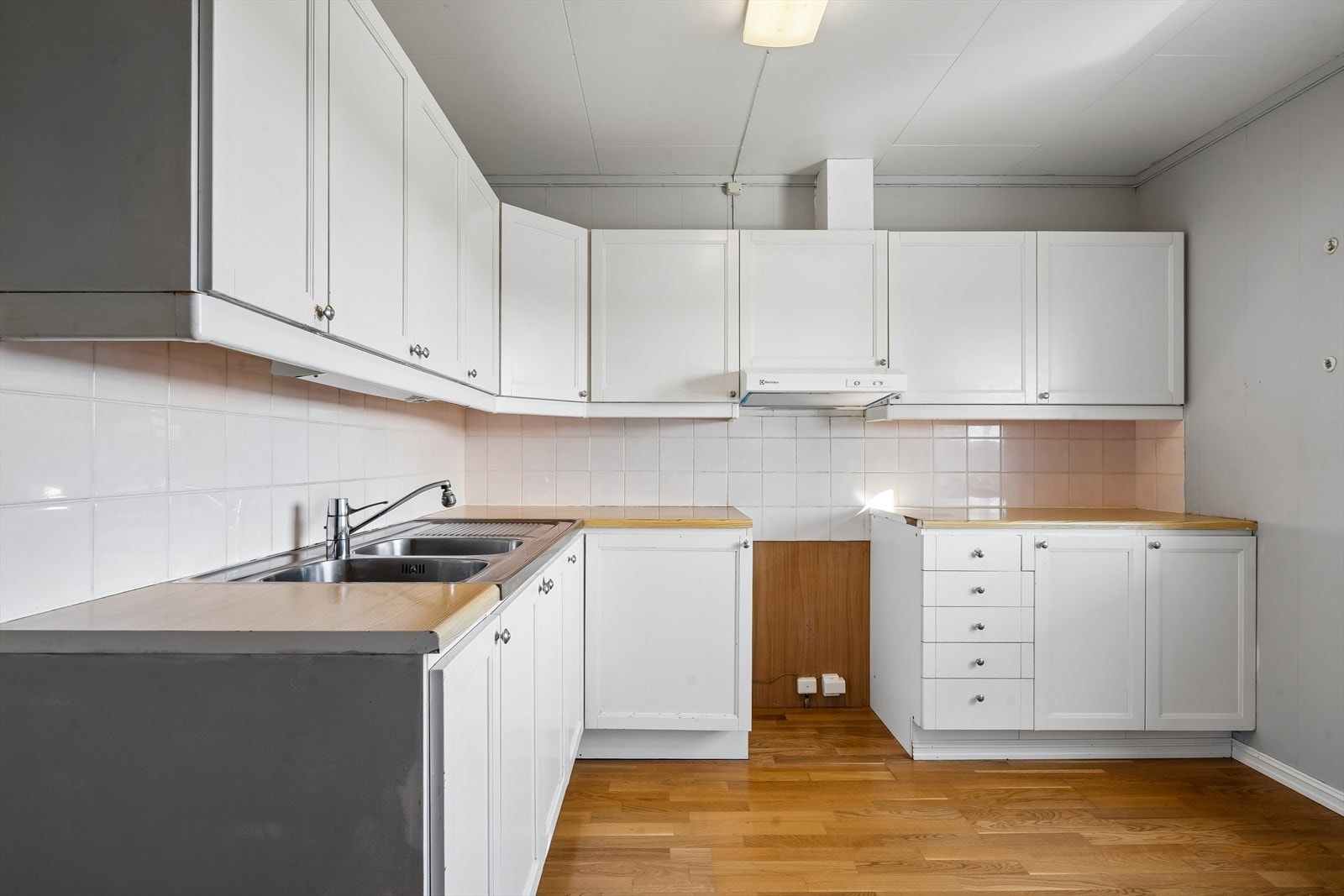 Innredningen er utstyrt med ventilator over komfyr og dobbel oppvaskkum i stål. Galleribilde