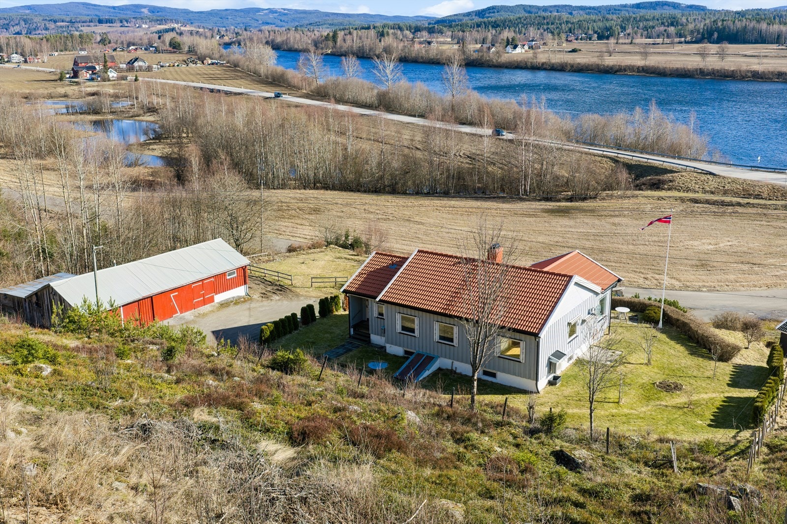 Eiendommen har en pent opparbeidet tomt og en stor, frittliggende garasje/uthusbygning. Galleribilde