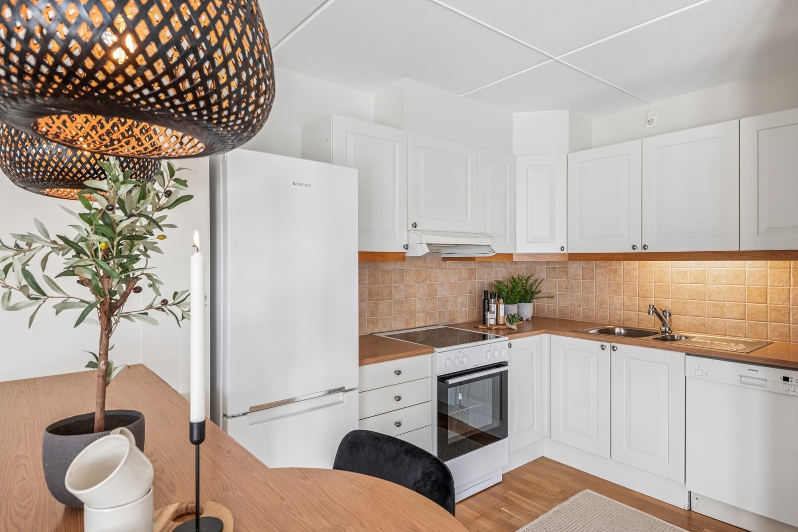 Det er fliser mellom benk og overskap, samt belysning og stikkontakter under overskapene Galleribilde