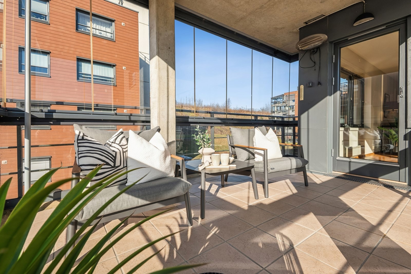 Innglassingen gjør balkongen til et lunt og anvendelig uterom store deler av året. Vinduene kan skyves til side Galleribilde