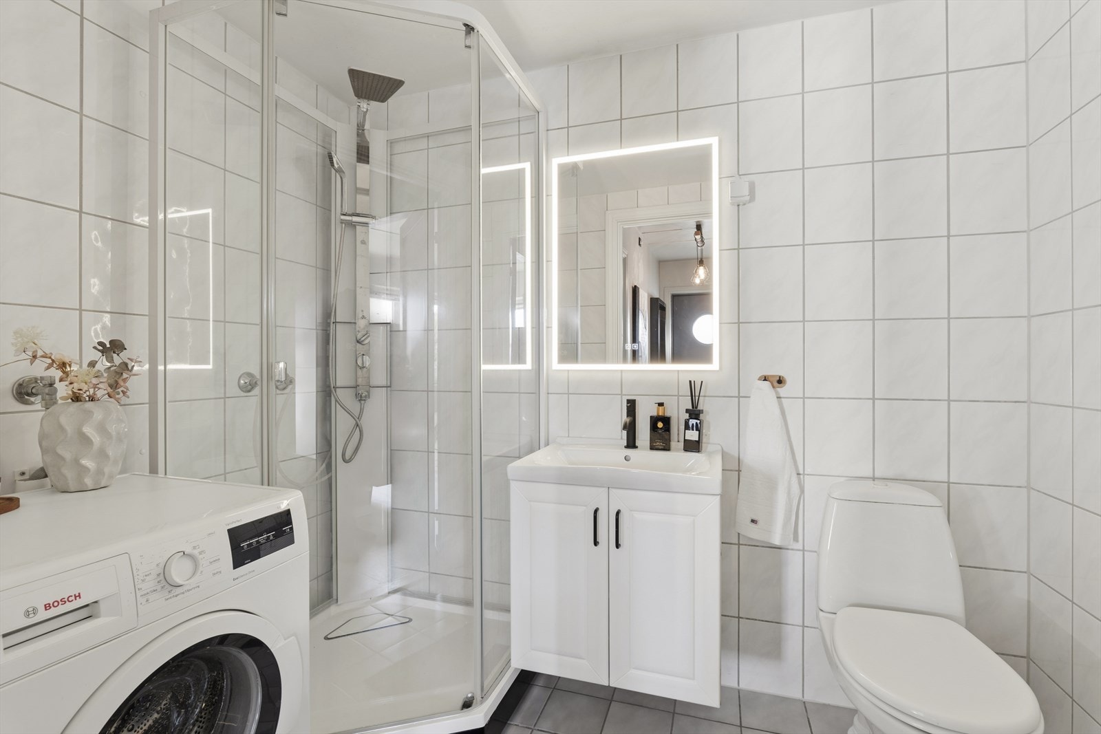 Badet har innredning med nedfelt servant, toalett, dusjkabinett
og opplegg for vaskemaskin Galleribilde