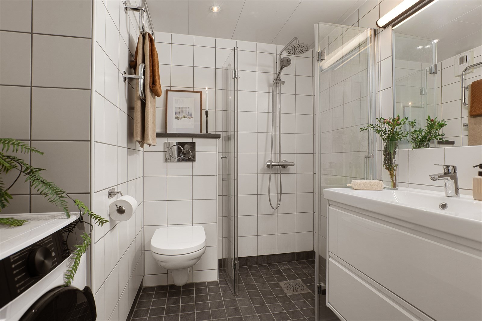 Flislagt baderom med varme i gulv, downlights i himling og opplegg for vaskemaskin, her er det plass til alt du trenger. Galleribilde