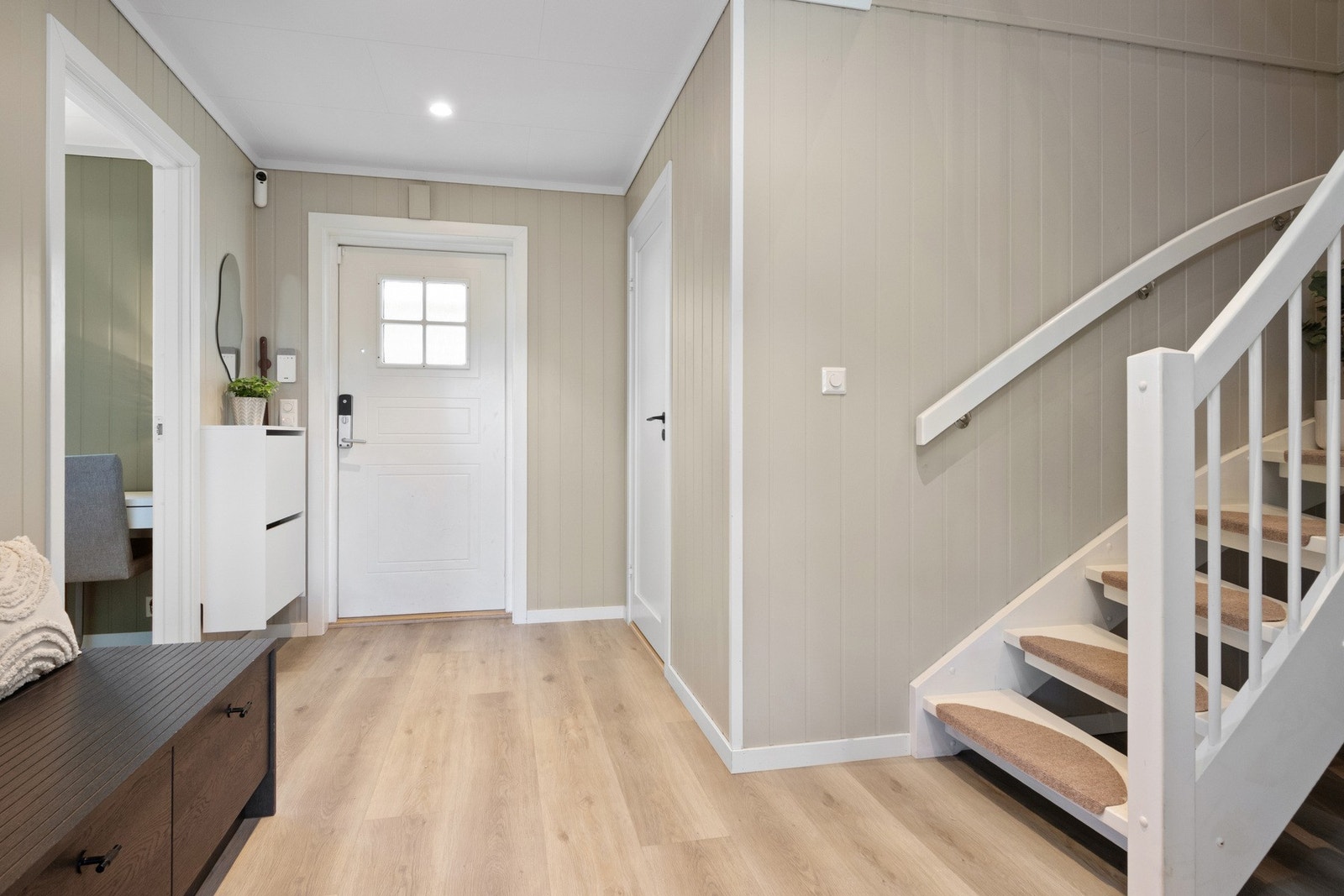 Gangen er stilren og helhetlig utført med downlights, 1-stavs laminatgulv og lyse panelplater på veggene. Galleribilde