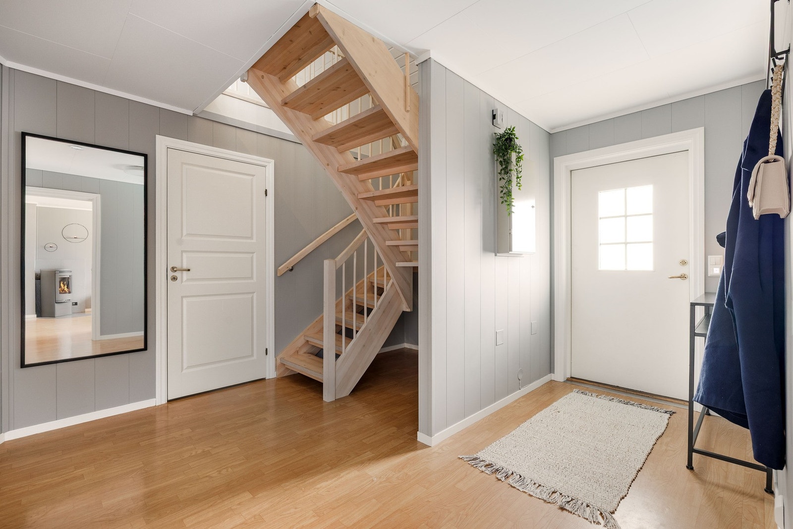 Videre inn i gangen finner du rikelig med oppbevaringsplass under trappen - praktisk for både store og små. Galleribilde