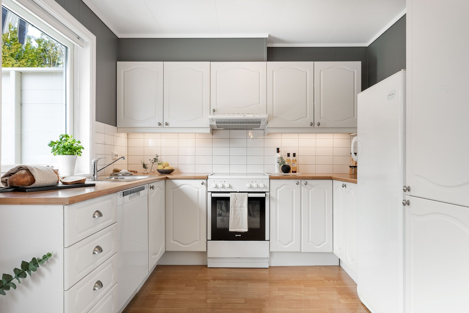 Lyst og praktisk kjøkken i åpen løsning mot stuen, med frittstående hvitevarer. Galleribilde