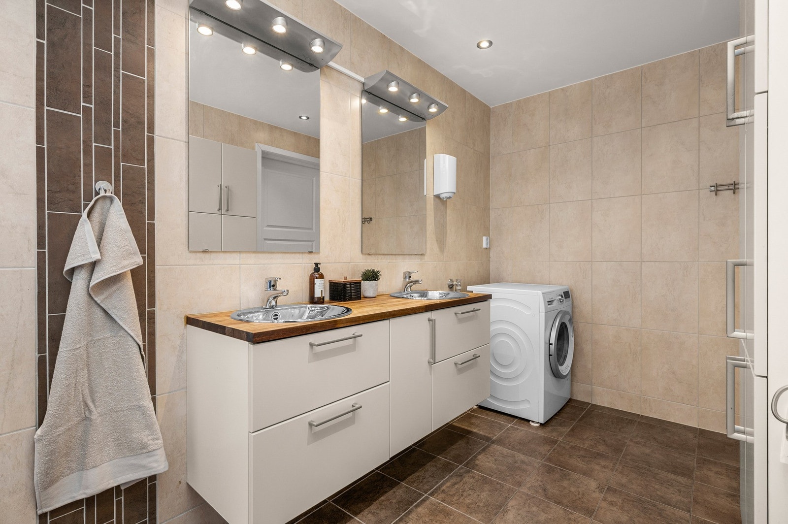 Badet har mye oppbevaringsplass og opplegg til vaskemaskin og plass til tørketrommel. Galleribilde