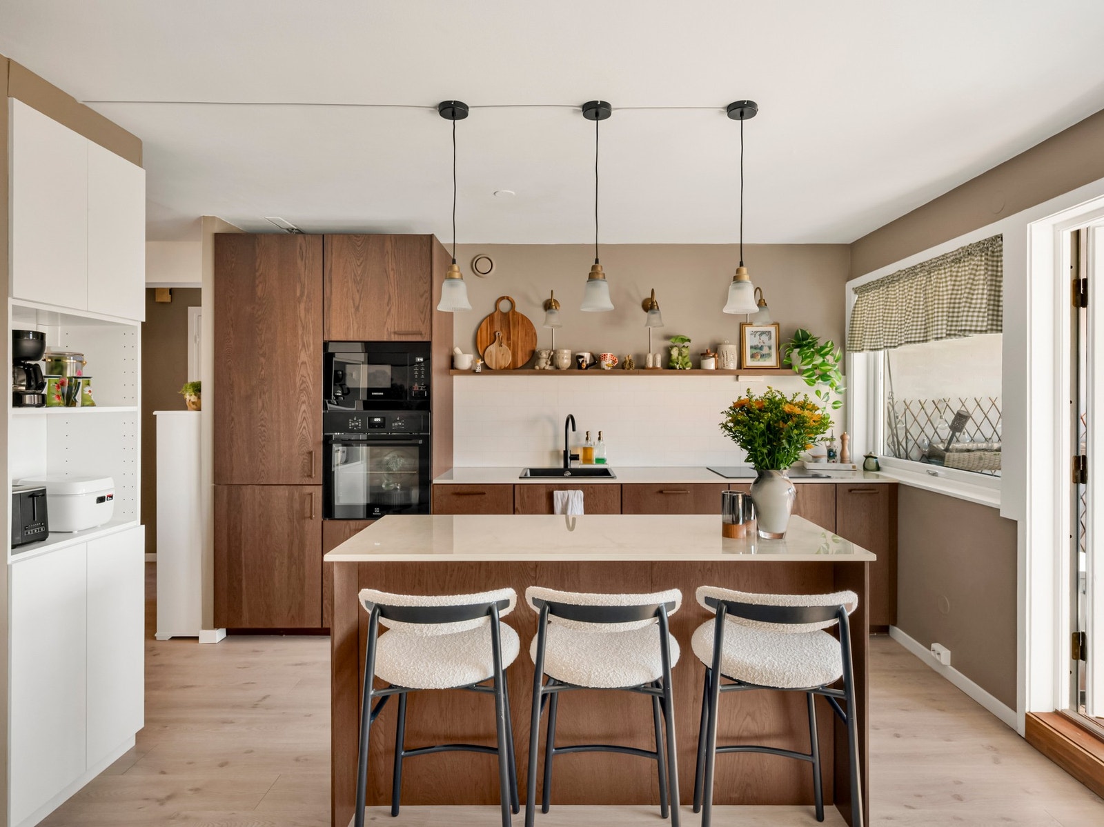 Kjøkkeninnredning fra IKEA med glatte fronter, integrerte hvitevarer som kjøl/fryseskap, oppvaskmaskin, induksjonstopp med integrert ventilator i kjøkkenbenk mikro og stekeovn. Galleribilde