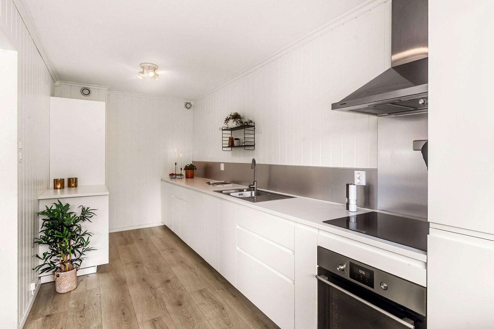 Kjøkkeninnredning med slette fronter, laminatbenkeplate og integrert stekeovn og koketopp. Galleribilde