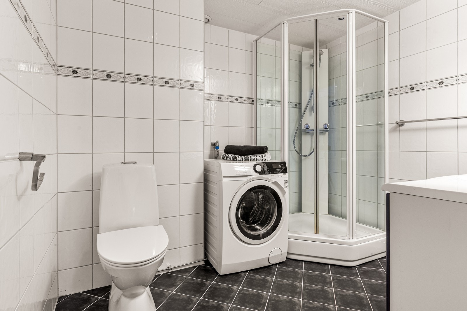 Badet har flislagt gulv med elektriske varmekabler og opplegg for vaskemaskin. Galleribilde
