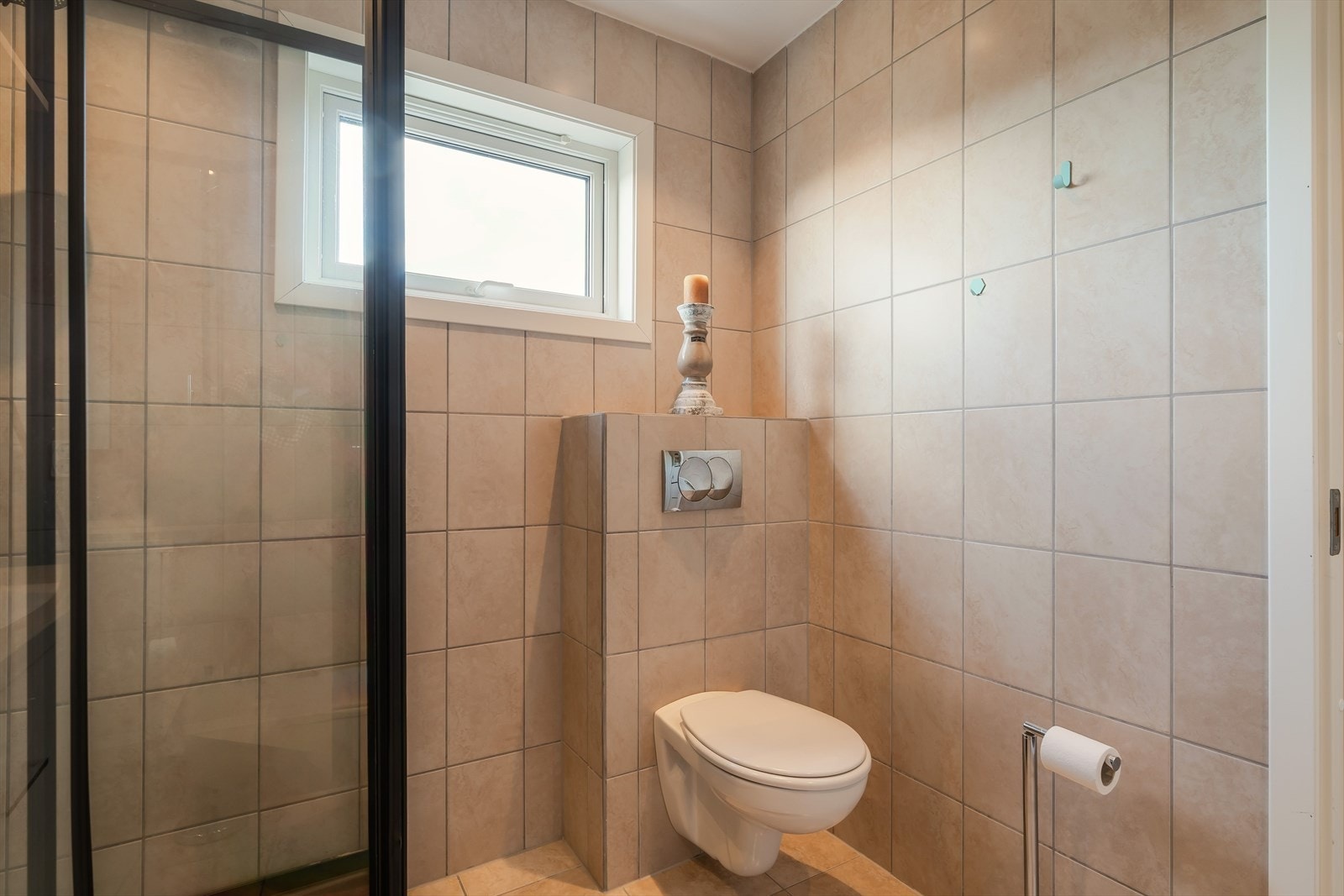 Badet består av toalett, dusjkabinett og skap med servant. Galleribilde