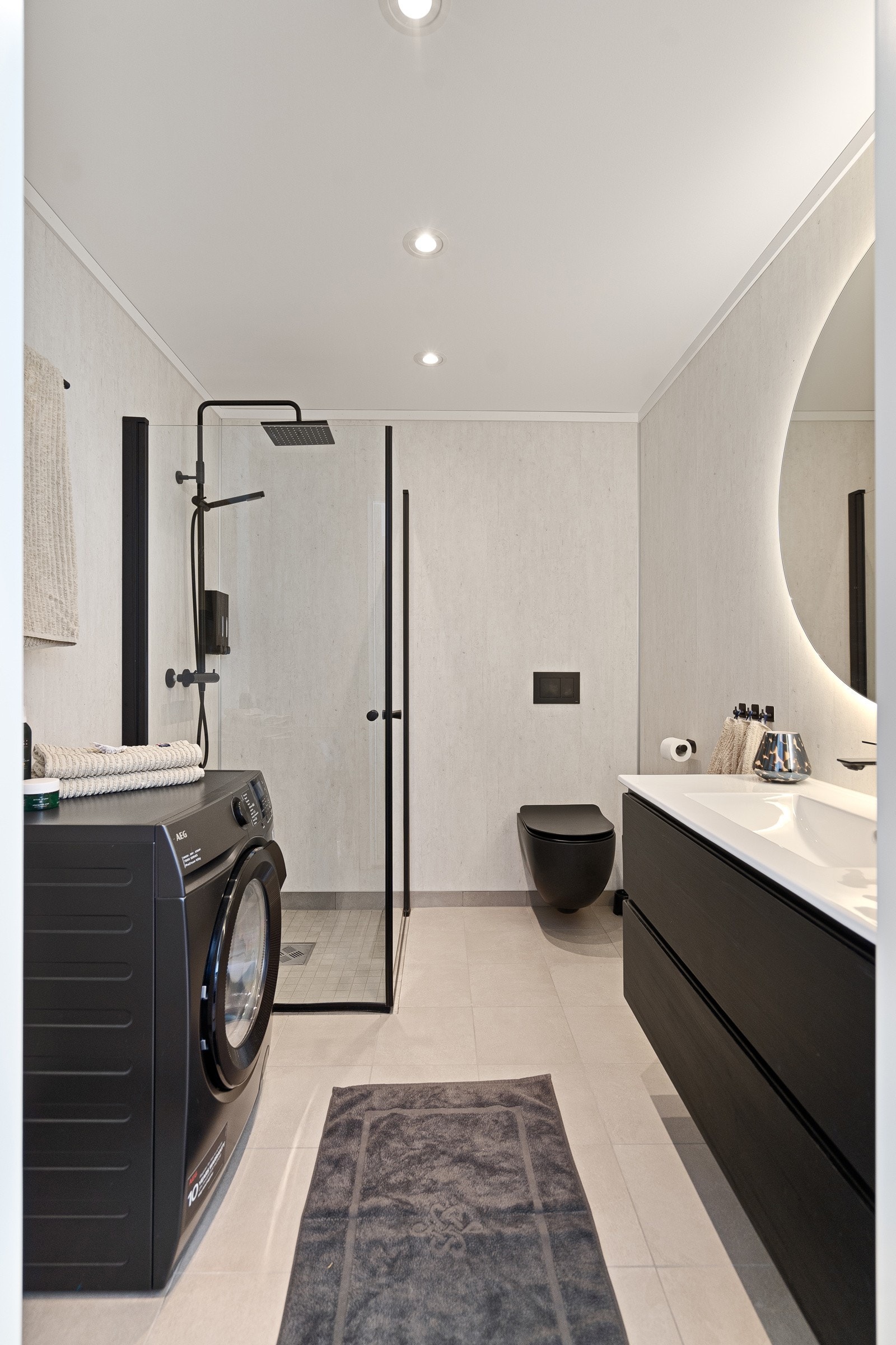 Delikat bad med dusjhjørne, varmekabler og opplegg for vaskemaskin Galleribilde