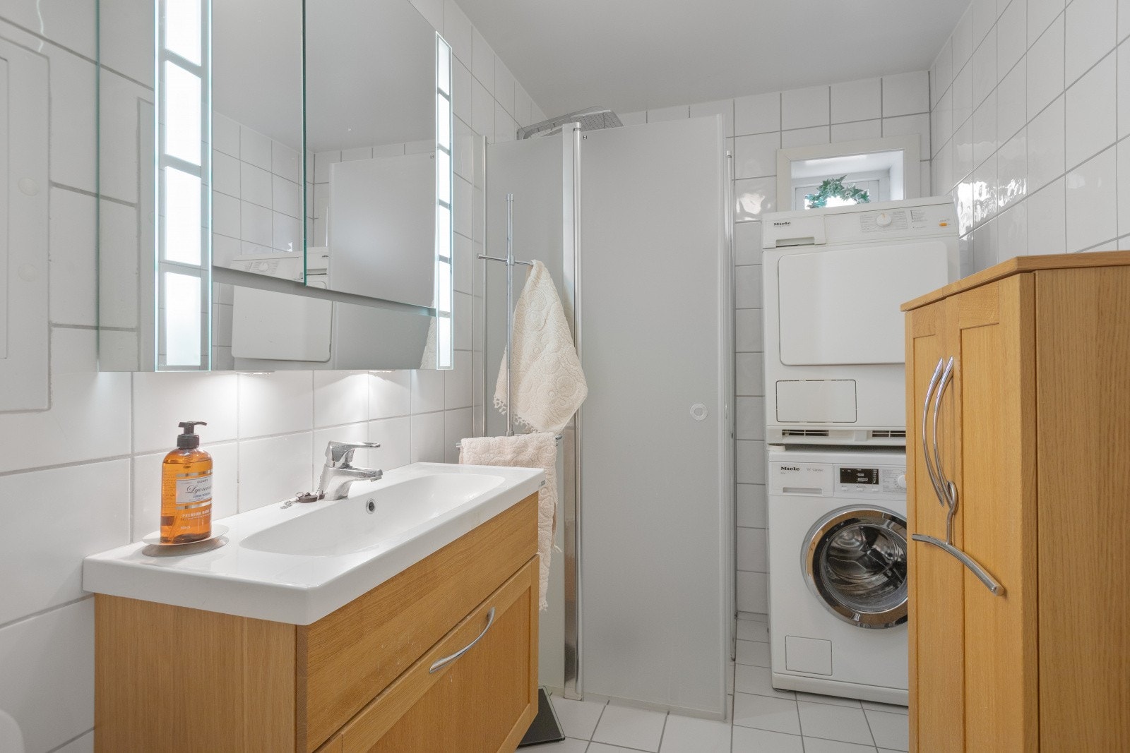 I likhet med toalettrommet er badet pent flislagt og har også nyere servantinnredning. Det er utstyrt med dusjdører og dusjsett, noe som gir et moderne preg og en praktisk løsning for daglig bruk. Galleribilde